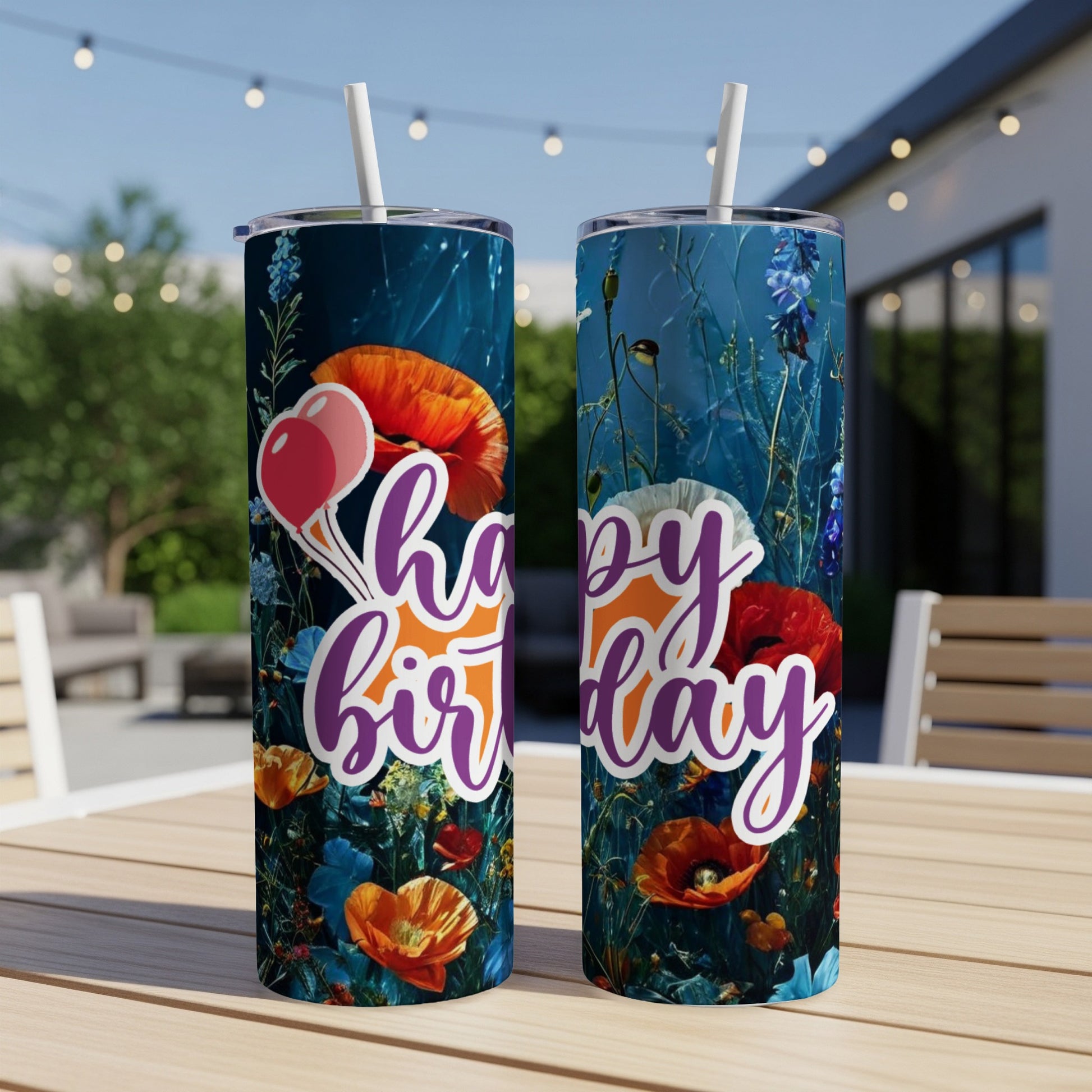 Two tumblers with a floral "Happy Birthday" design stand on a table.