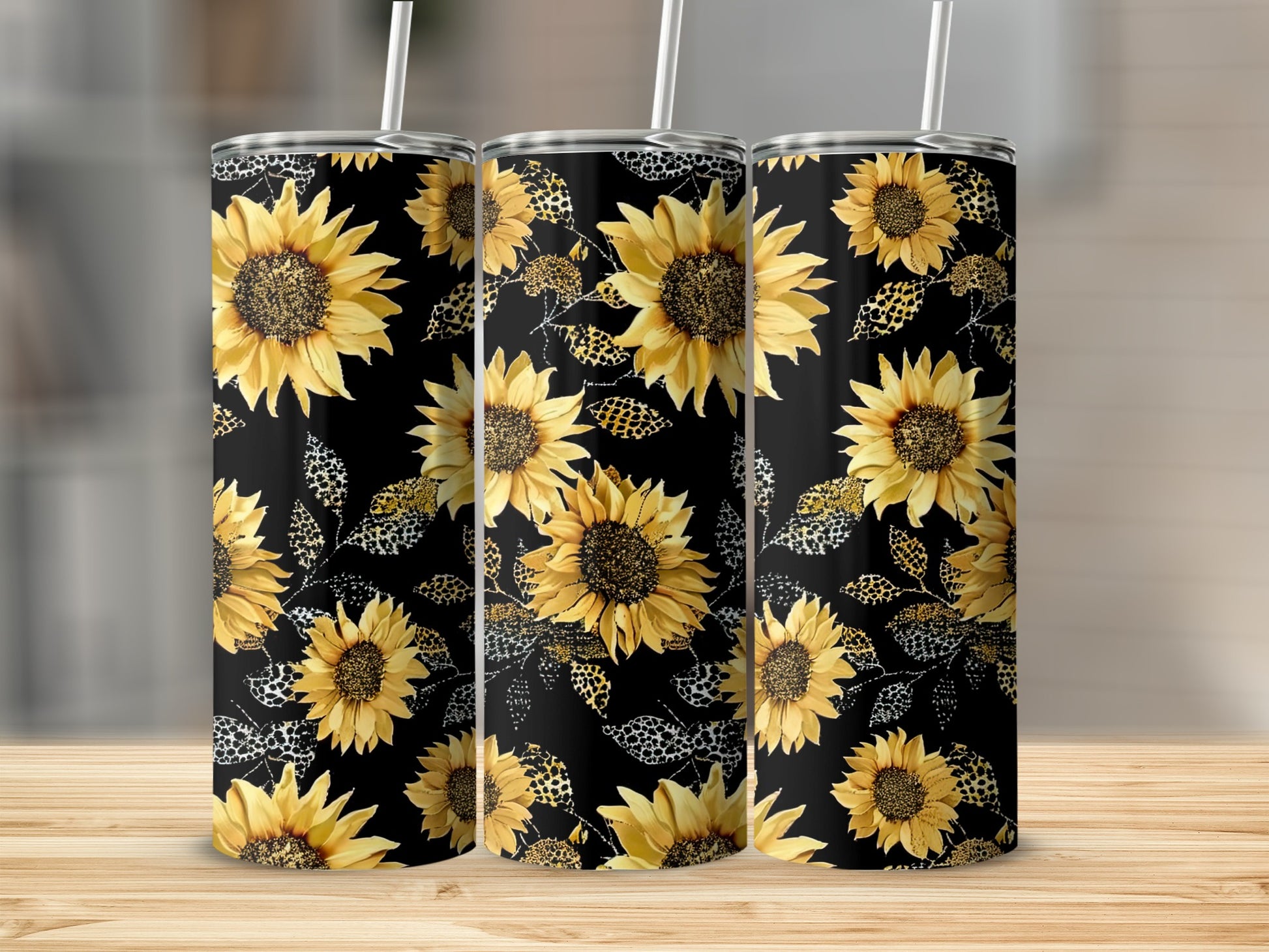 Three tumblers with a black background and yellow sunflower and leopard print designs.