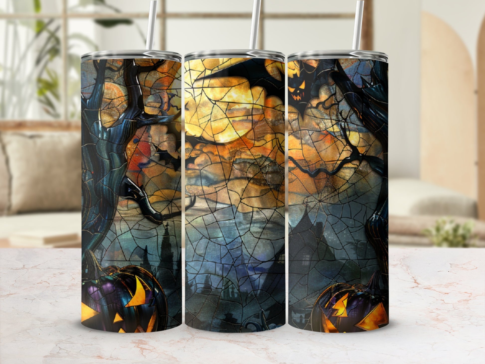 Three Halloween-themed tumblers with pumpkins and spooky trees.