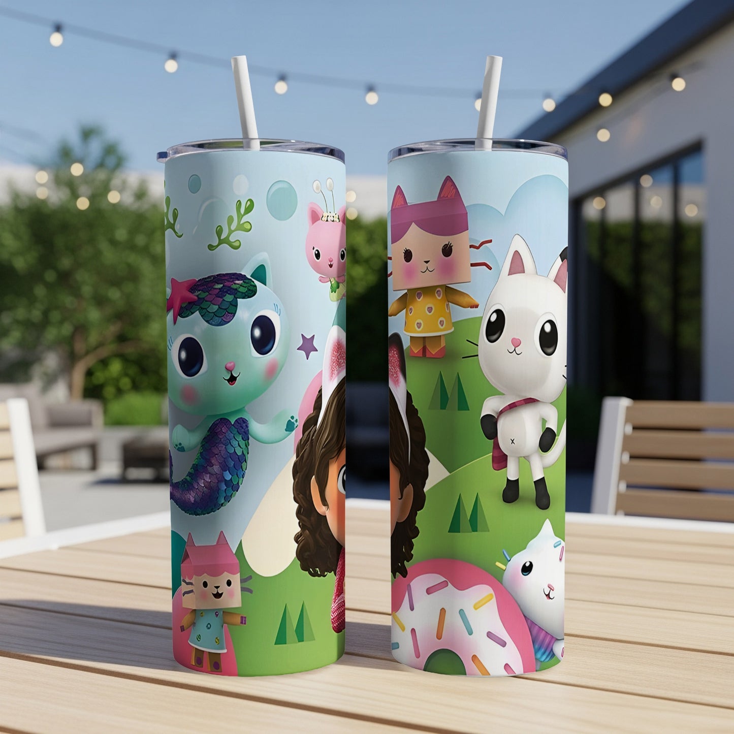 Two character-themed tumblers with straws, one with Gabby's Dollhouse characters, the other with a cat.