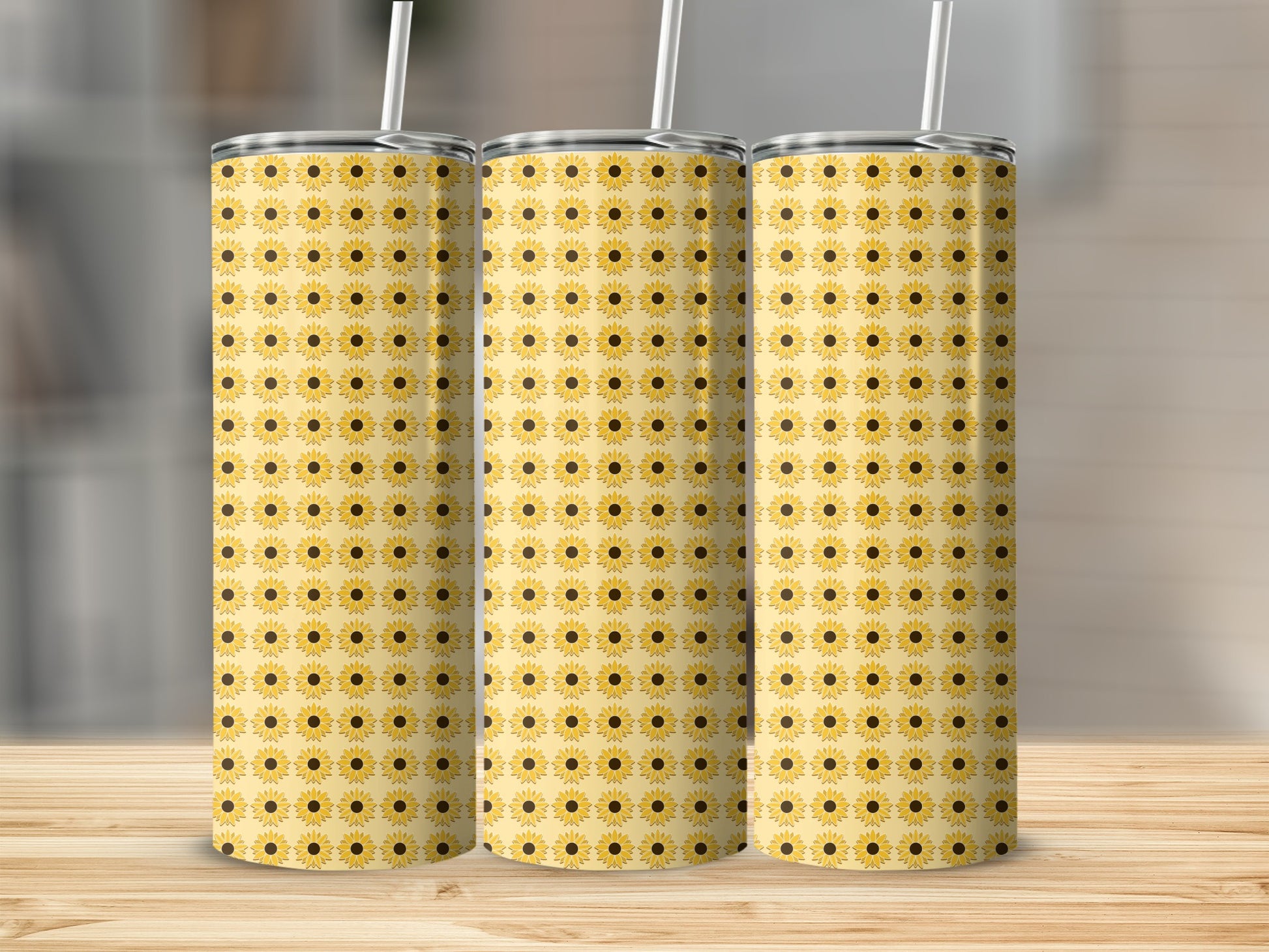 Three tumblers with a repeating yellow sunflower pattern on a wooden surface.