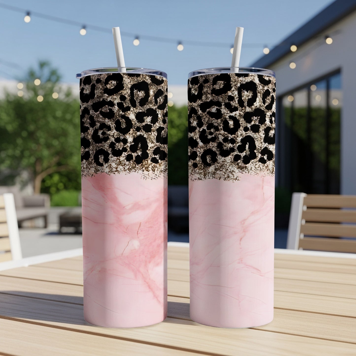 Two pink marble tumblers with leopard print tops and straws.