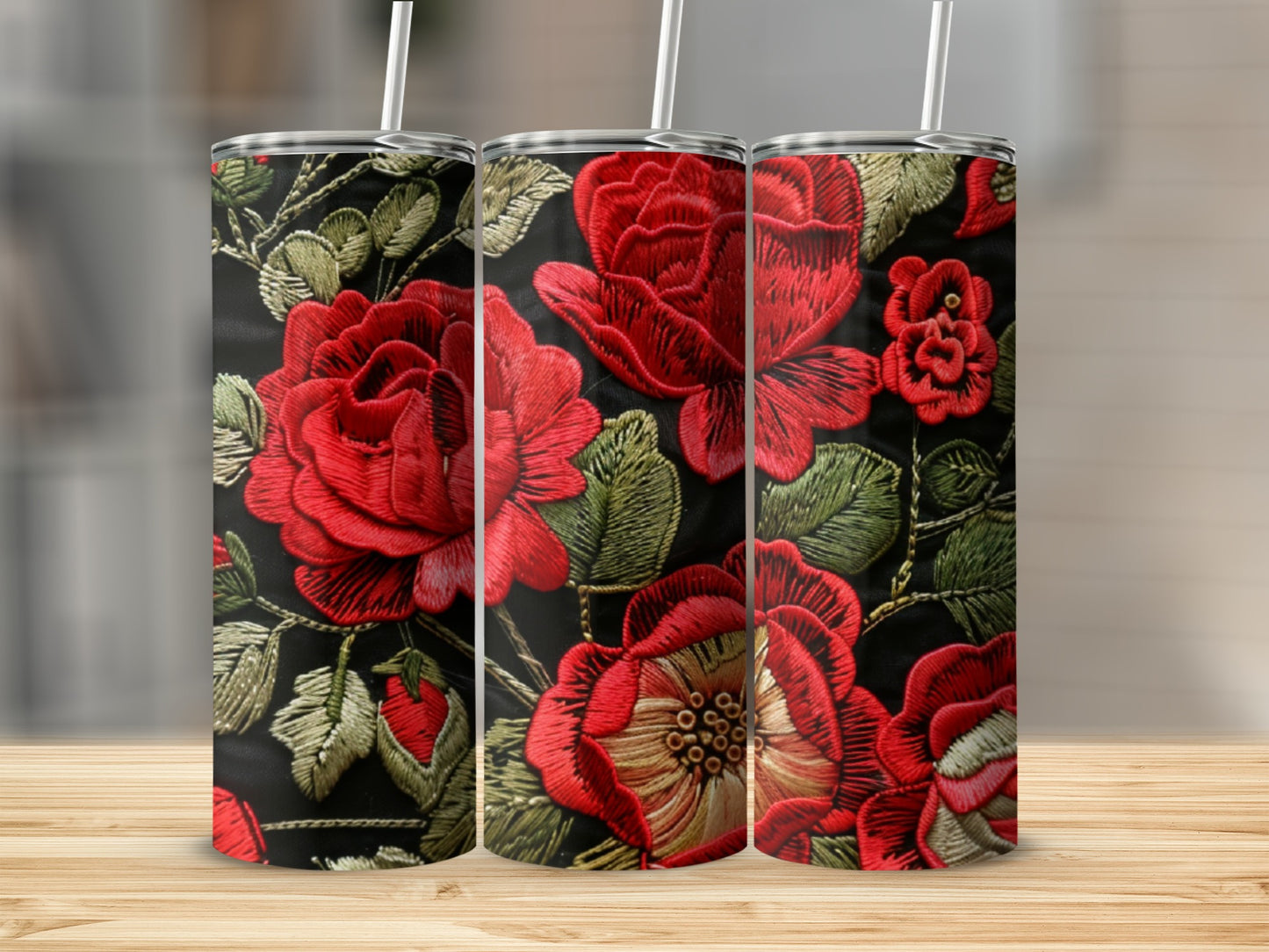 Three tumblers with vibrant red embroidered roses on a black background.