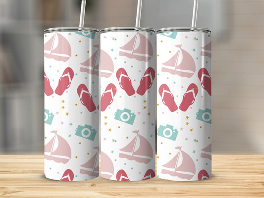 Sailboats, flip-flops, and cameras on a white patterned tumbler.