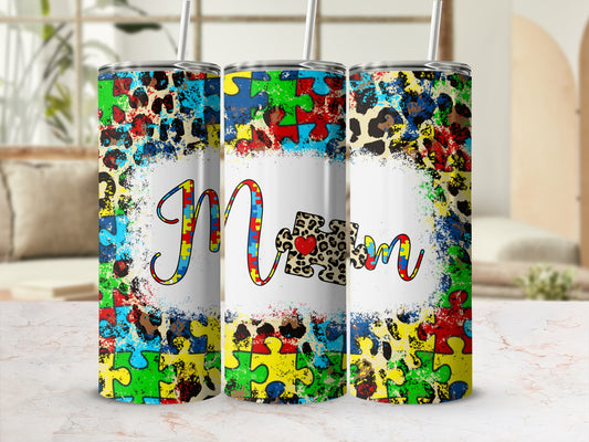 Tumbler with "Mom" in colorful puzzle pieces and leopard print.