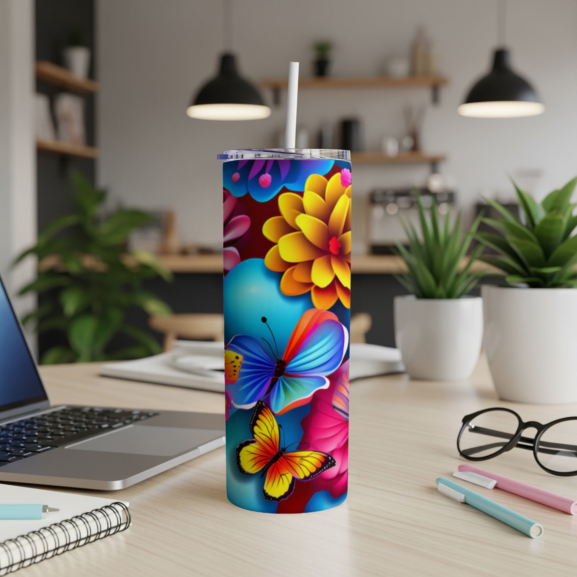 Blue tumbler with colorful butterflies and flowers, with a straw.