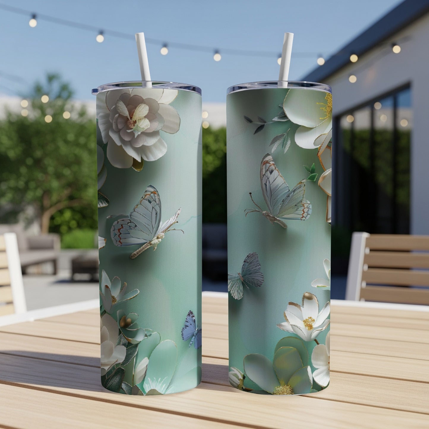 Two teal tumblers with white butterflies and floral illustrations.