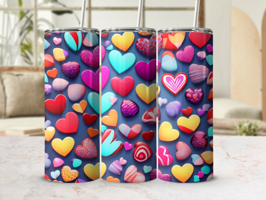 Three tumblers with a colorful, varied heart pattern, displayed on a patterned surface.