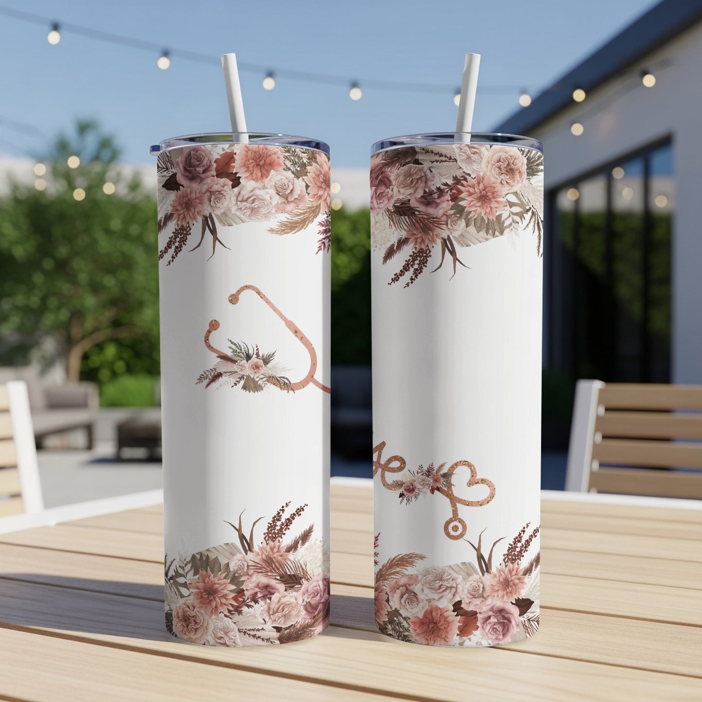 Two white tumblers with floral and stethoscope designs sit on a wooden table.