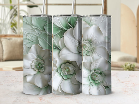 Three tumblers with raised white and green floral designs on a blurred background.