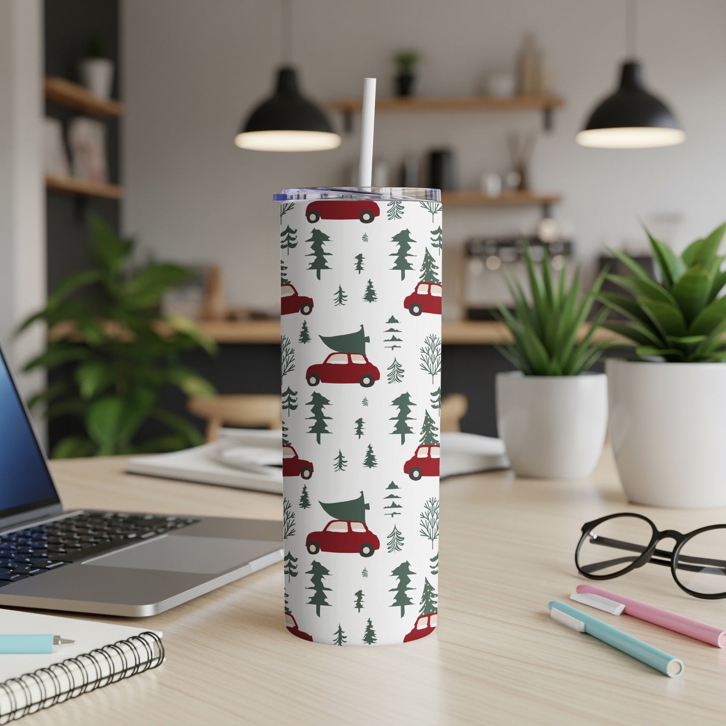 White tumbler with red cars and green trees pattern, straw extended.