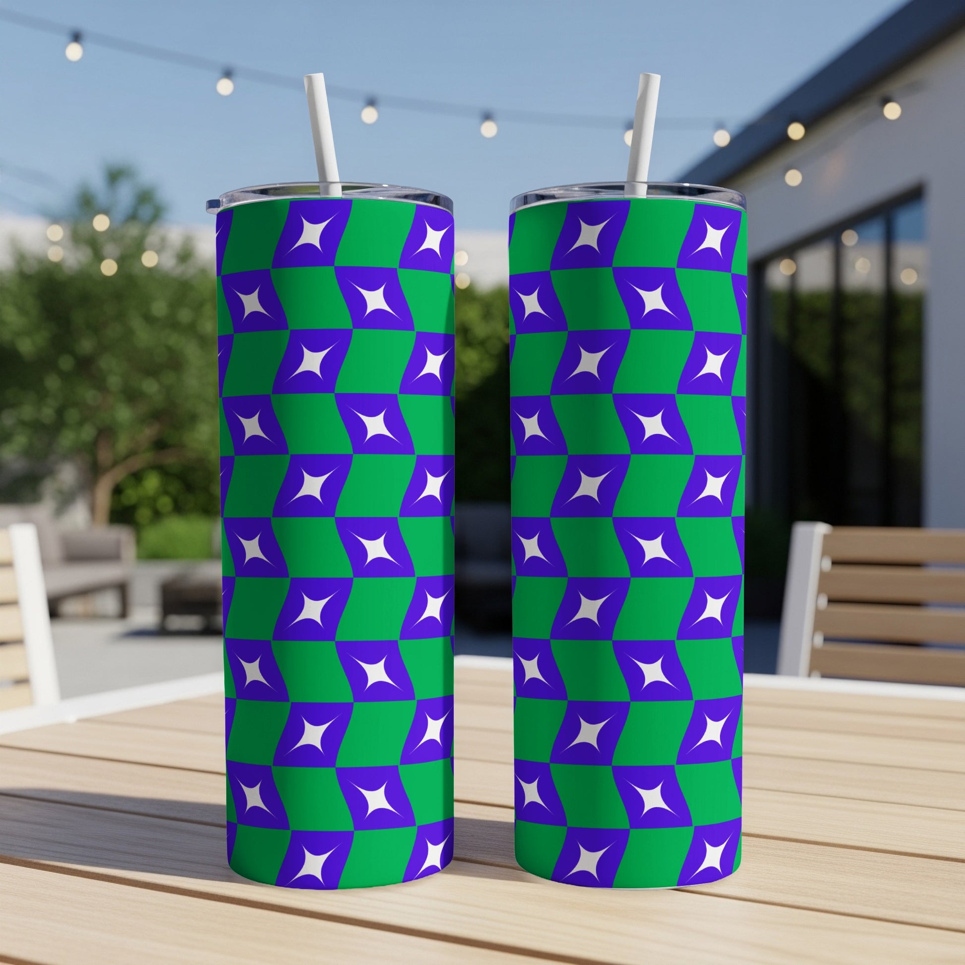 Two green and purple geometric pattern tumblers with straws on a table.