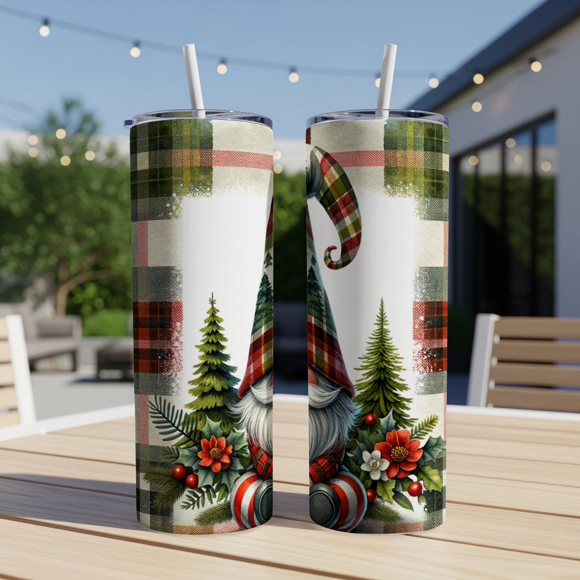 Two festive gnomes with plaid hats surrounded by pine trees and holly on white tumblers.