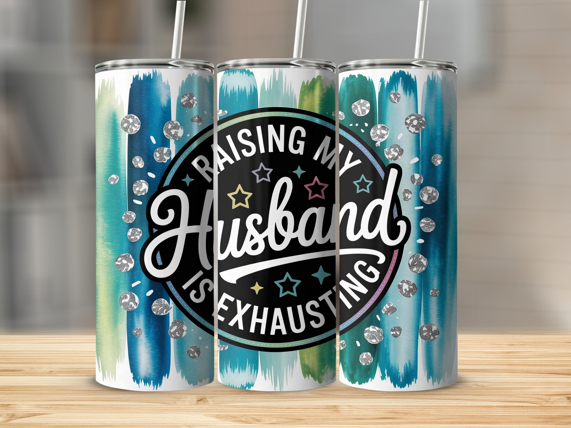 Tumbler with "Raising My Husband Is Exhausting" text and blue green watercolor brush strokes.