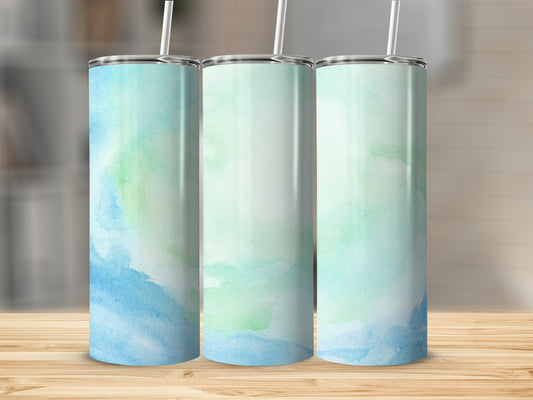 Three tall tumblers with a blue and green watercolor design on a wooden surface.