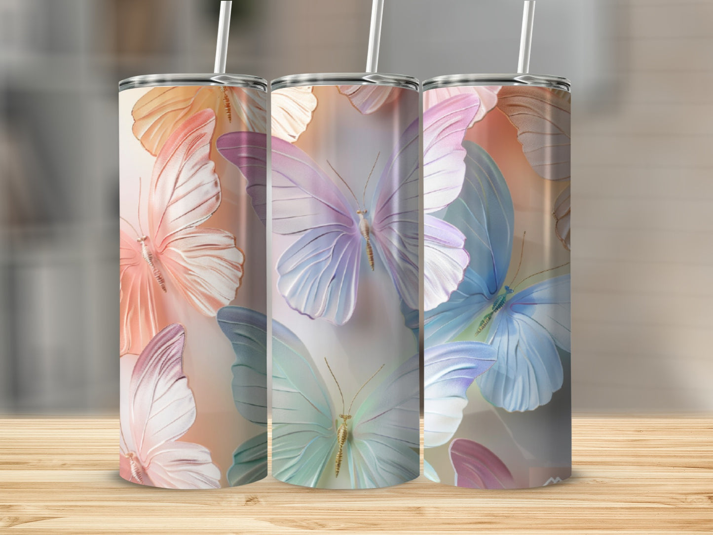 Three tumblers with iridescent butterfly designs on a wooden surface.