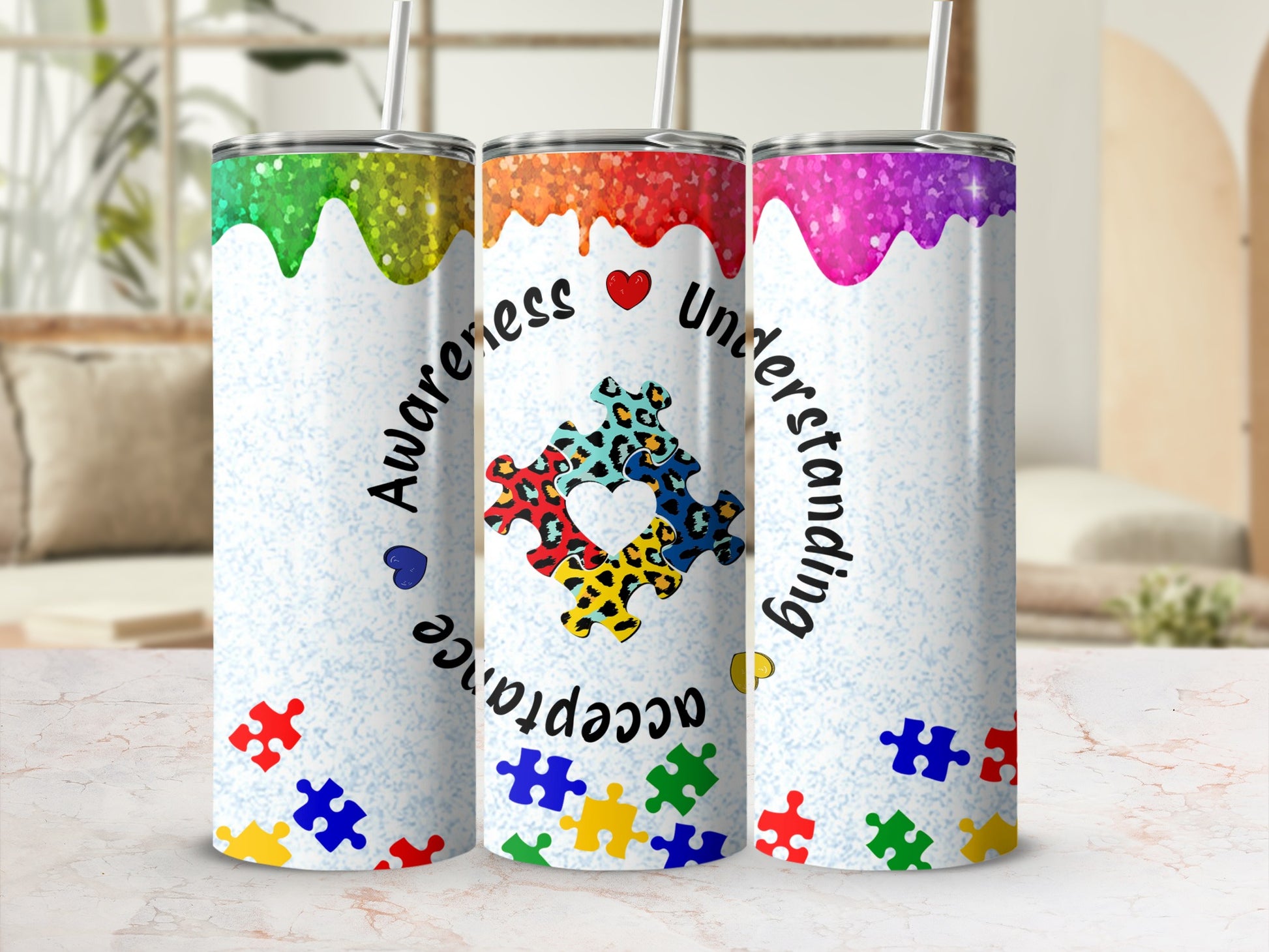 Three glitter tumblers with autism awareness puzzle piece design and text.