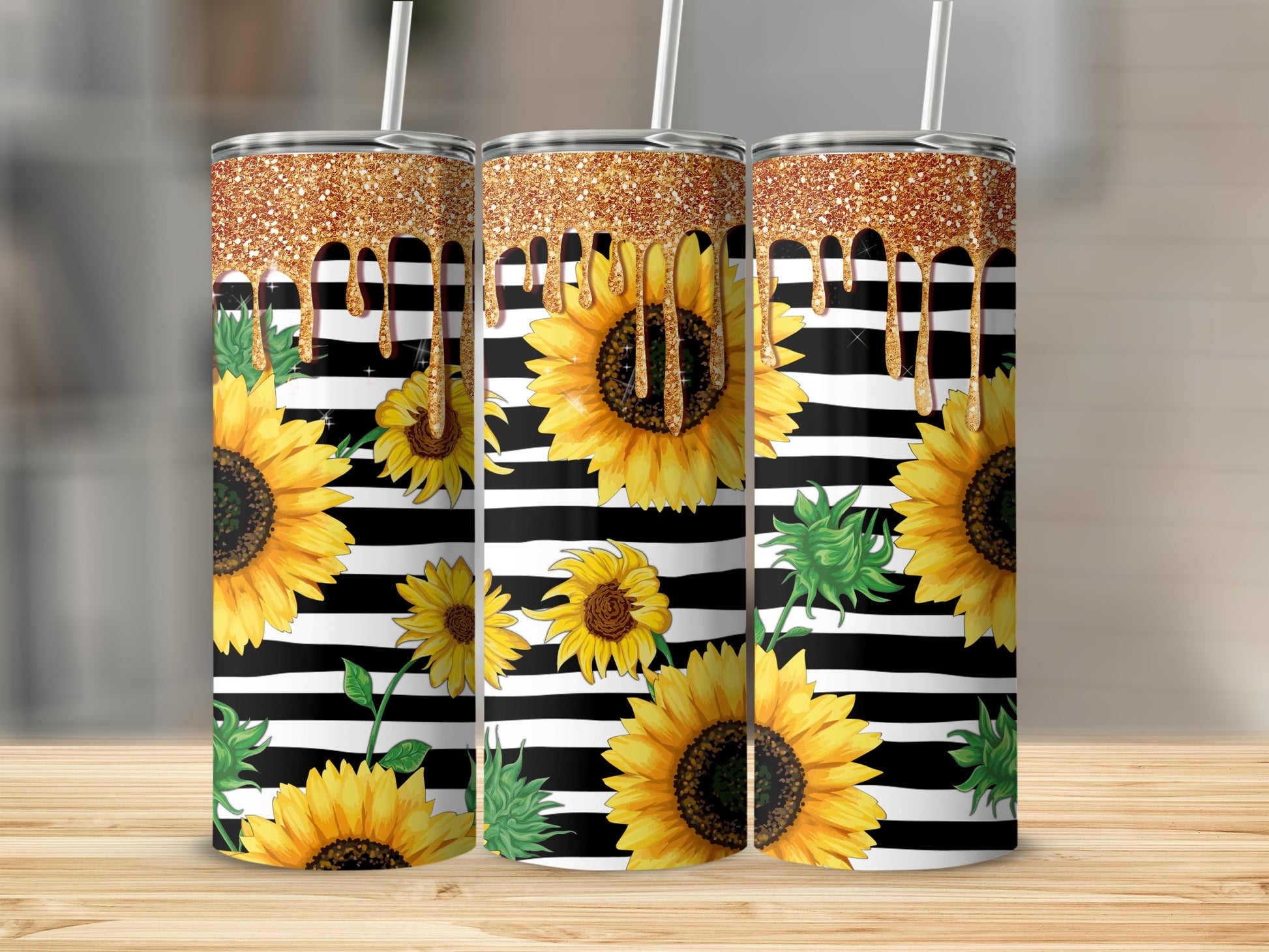 Three tumblers with sunflowers and gold glitter drips on black and white stripes.