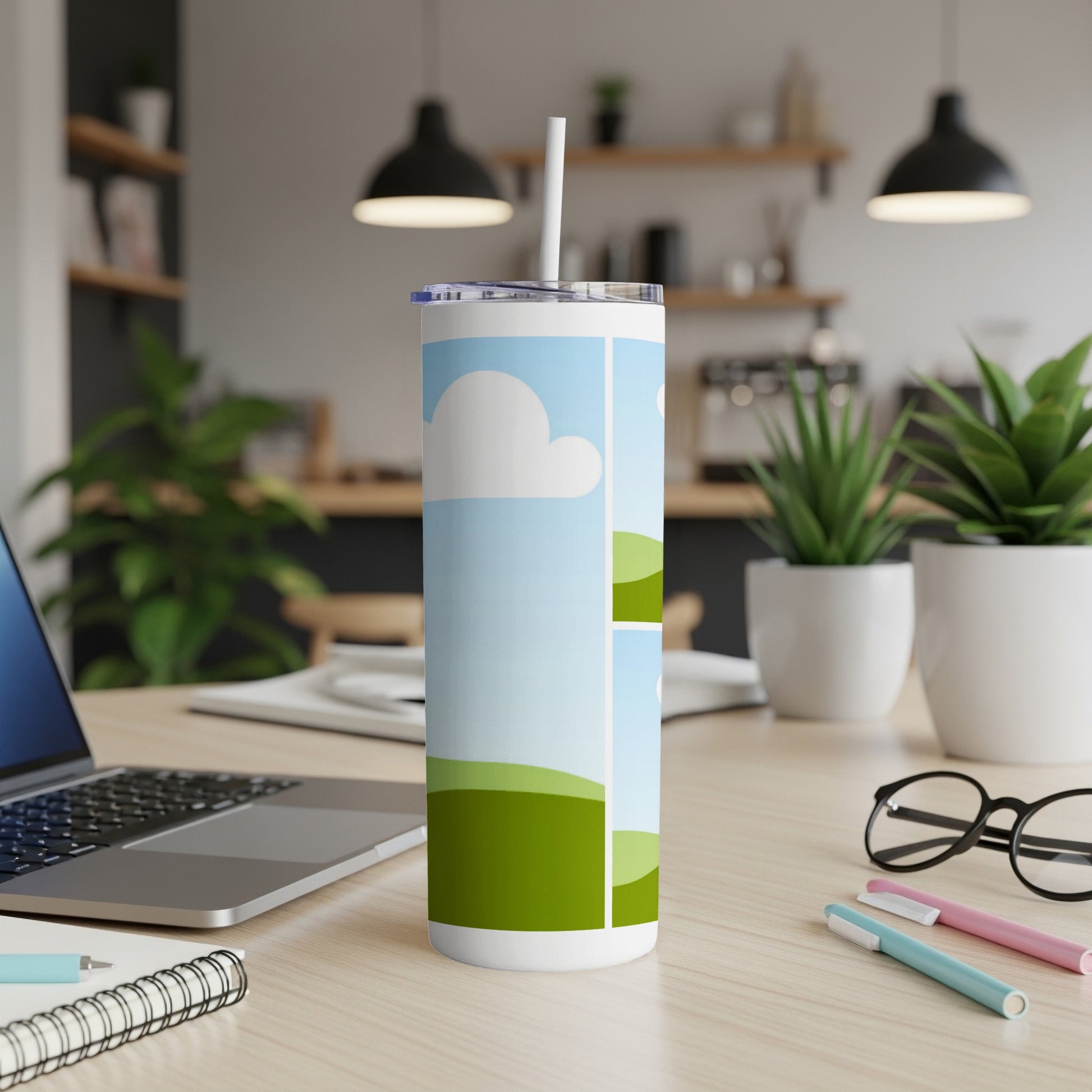 White tumbler with a cartoon landscape design, featuring clouds and green hills.