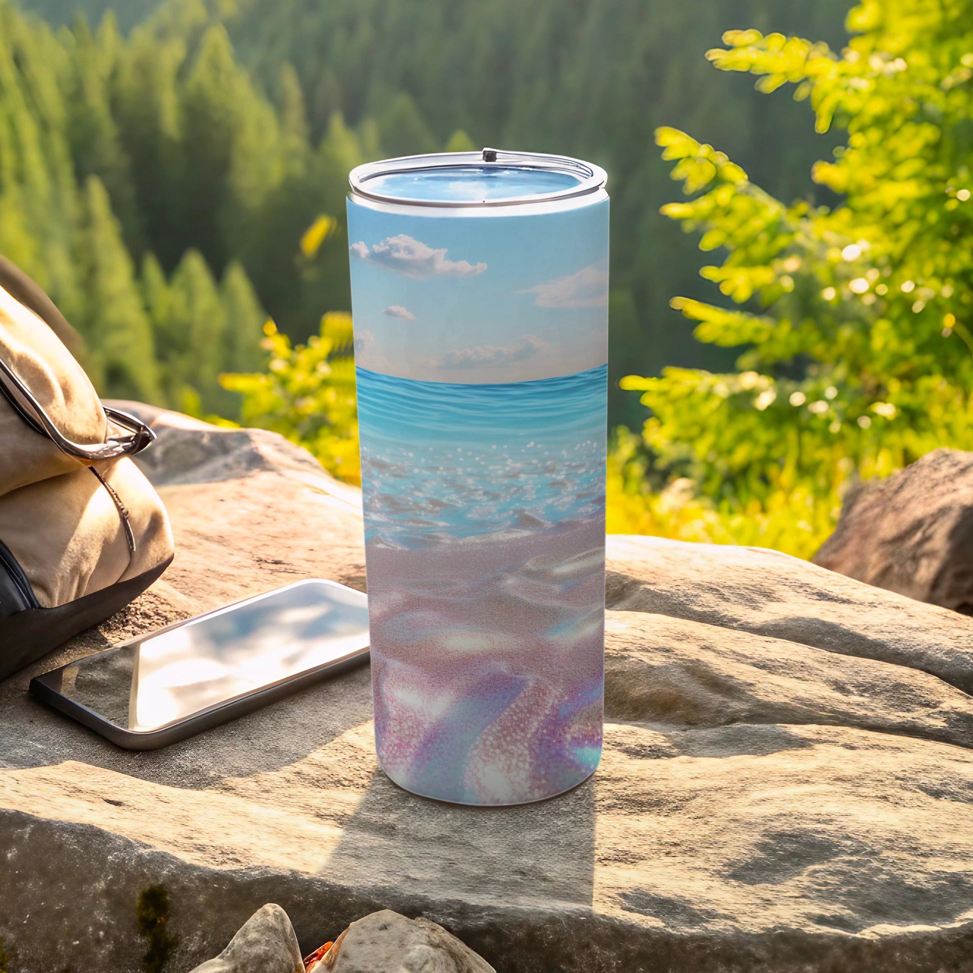 Ocean waves and sand pattern on a tumbler with a phone and backpack.