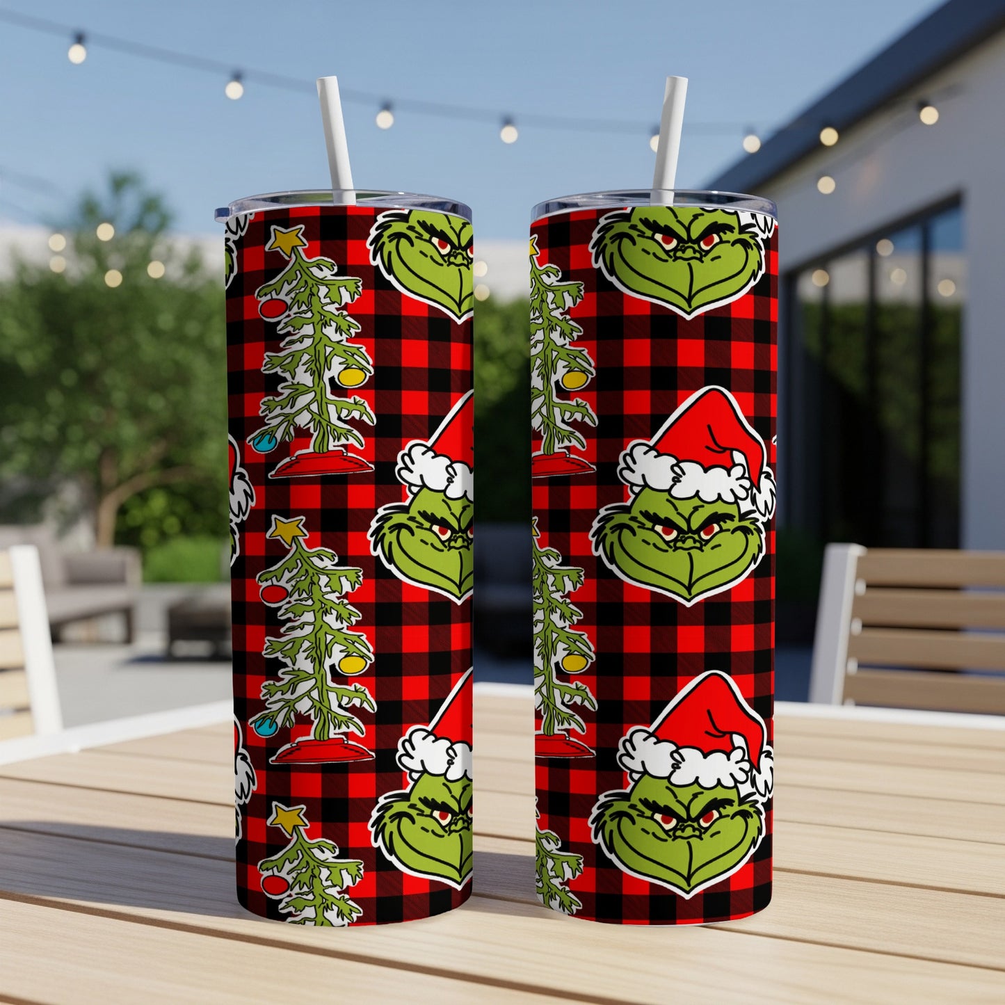 Green Grinch face with Santa hat and skinny Christmas tree on plaid background.