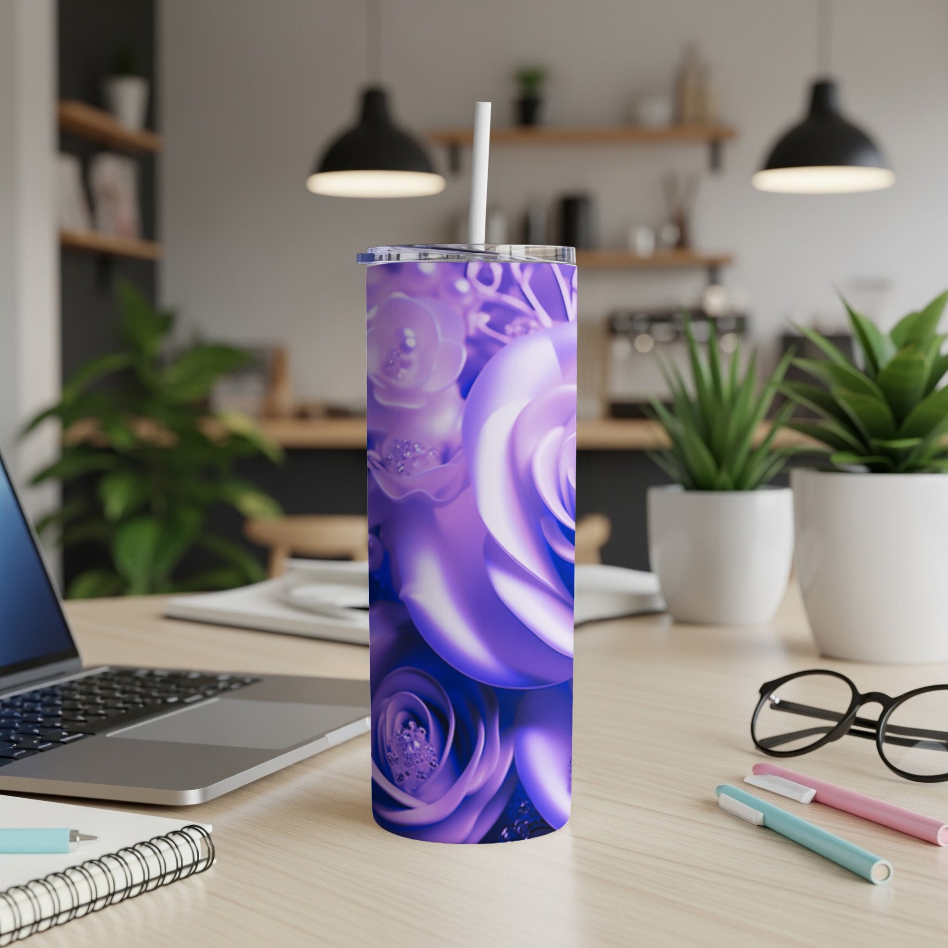Purple roses wrap around a tumbler with a straw on a desk.