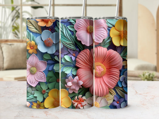 Three colorful floral tumblers with straws on a marbled surface.