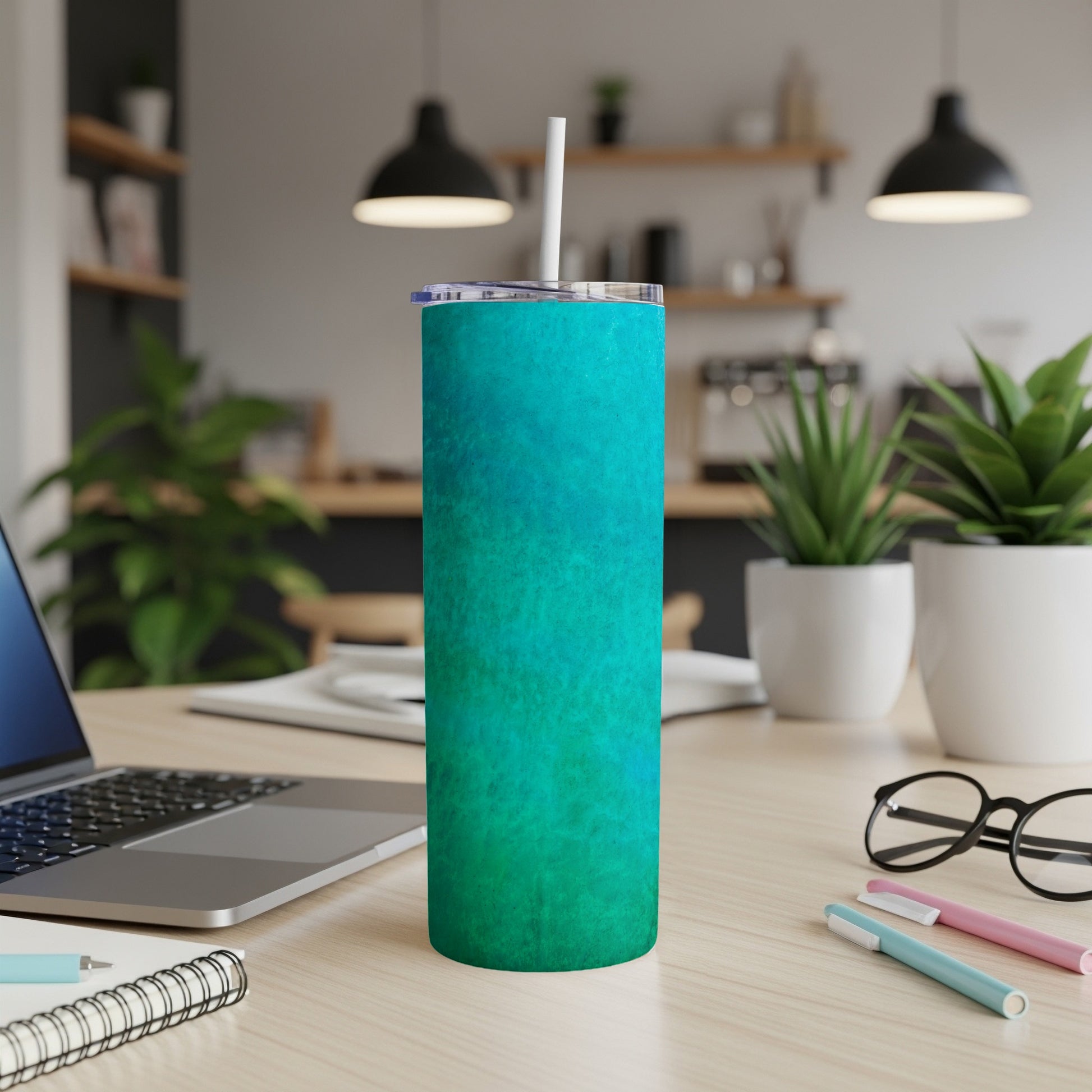Turquoise and teal textured tumbler with a white straw on a desk.