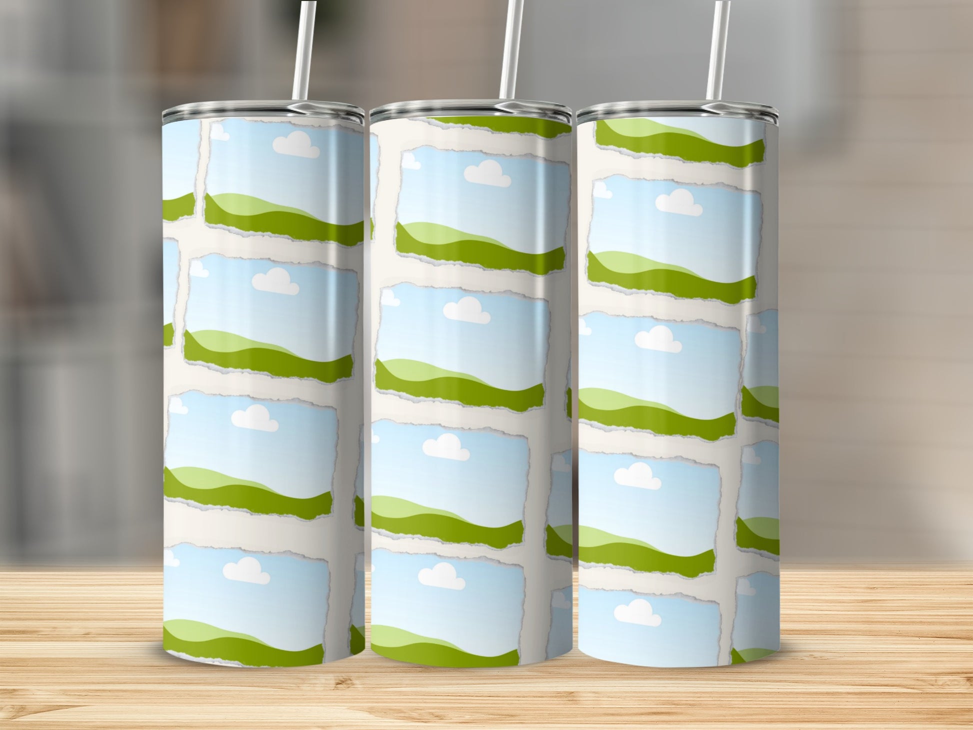 Three tumblers with a torn paper pattern featuring green hills and blue sky.