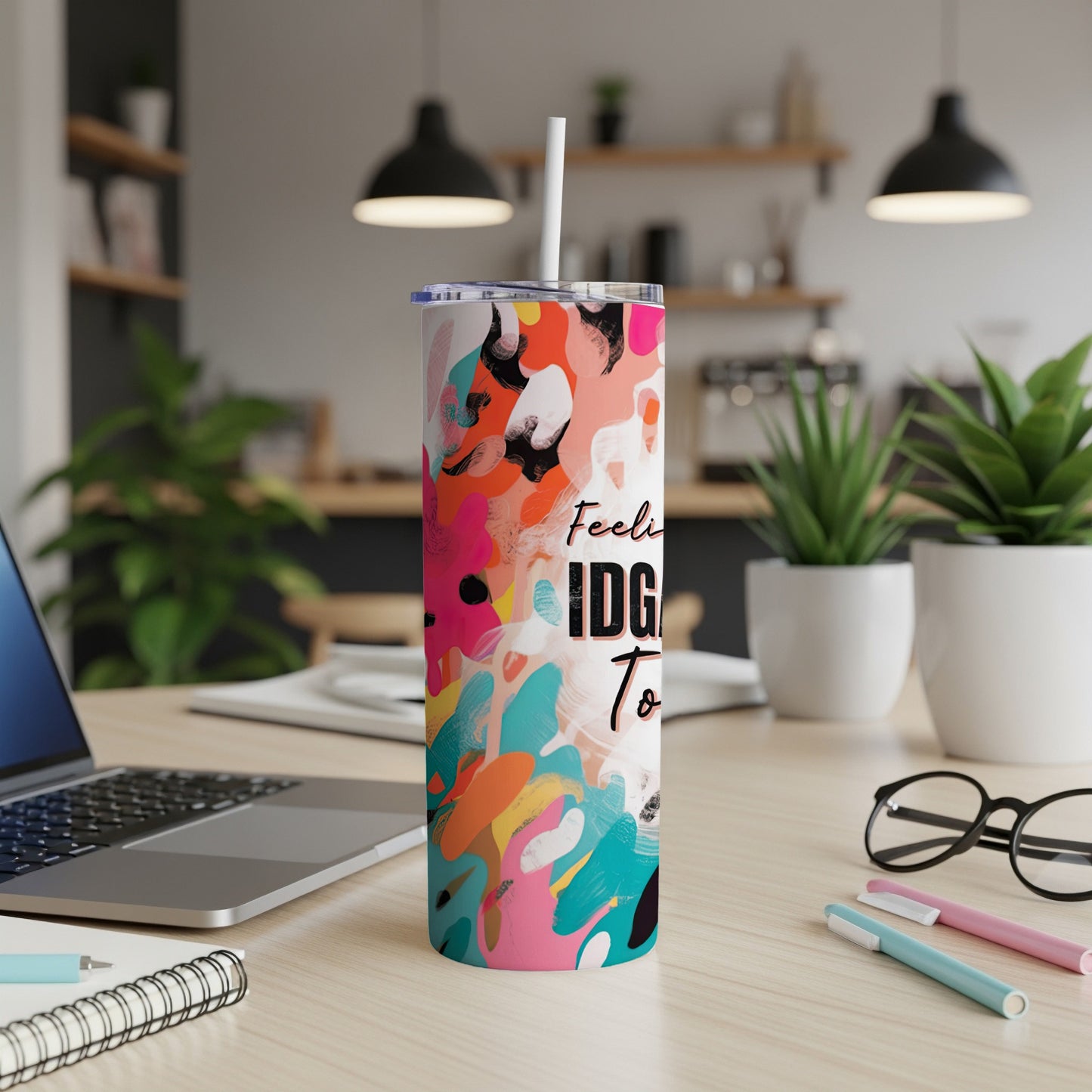 Tall tumbler with colorful abstract paint splotches and "Feeling Idgaf To" text.
