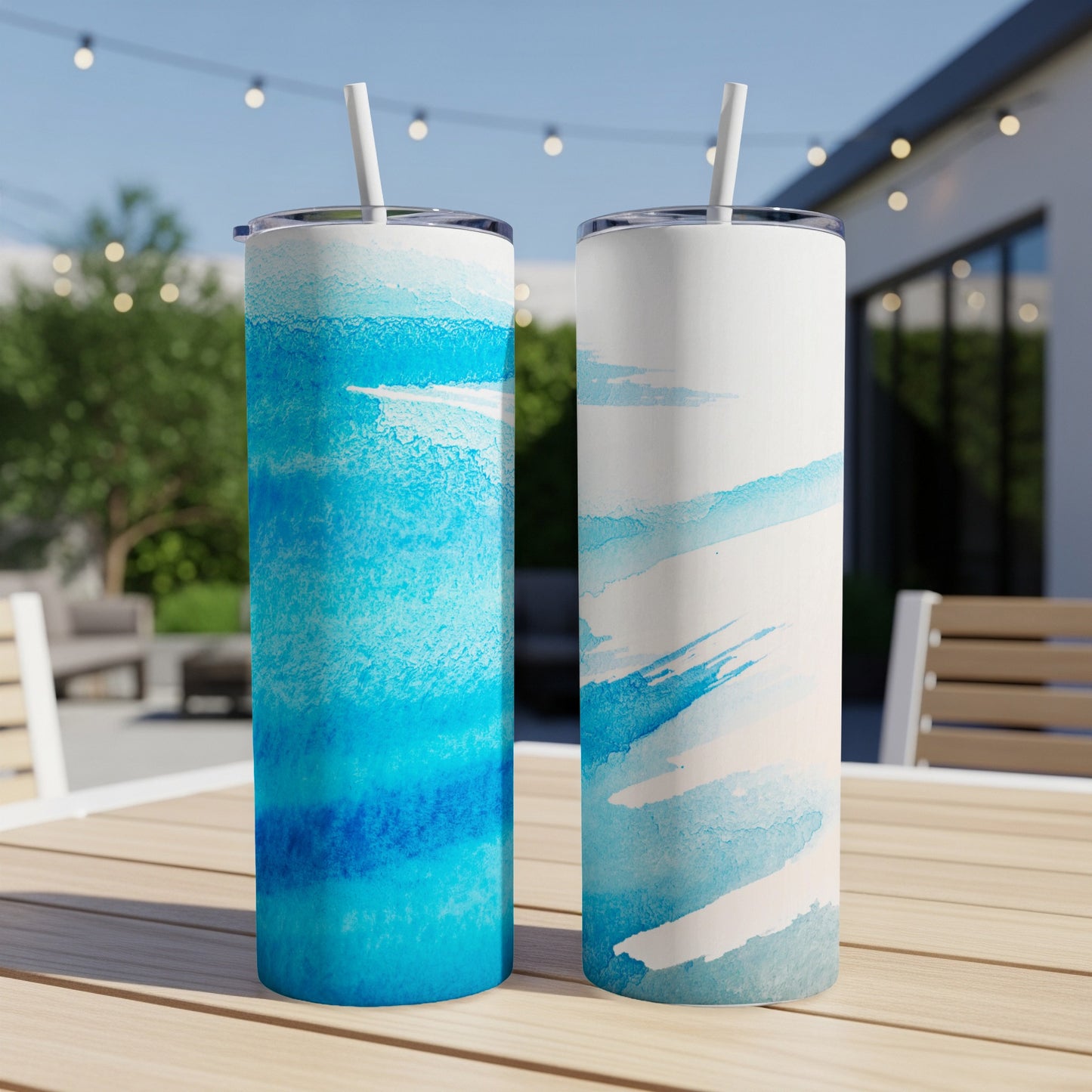 Two tumblers with abstract blue watercolor designs on a table.