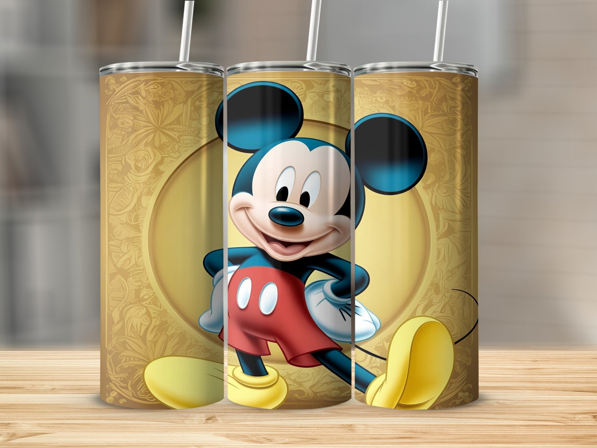 Mickey Mouse on a gold patterned tumbler with a straw.