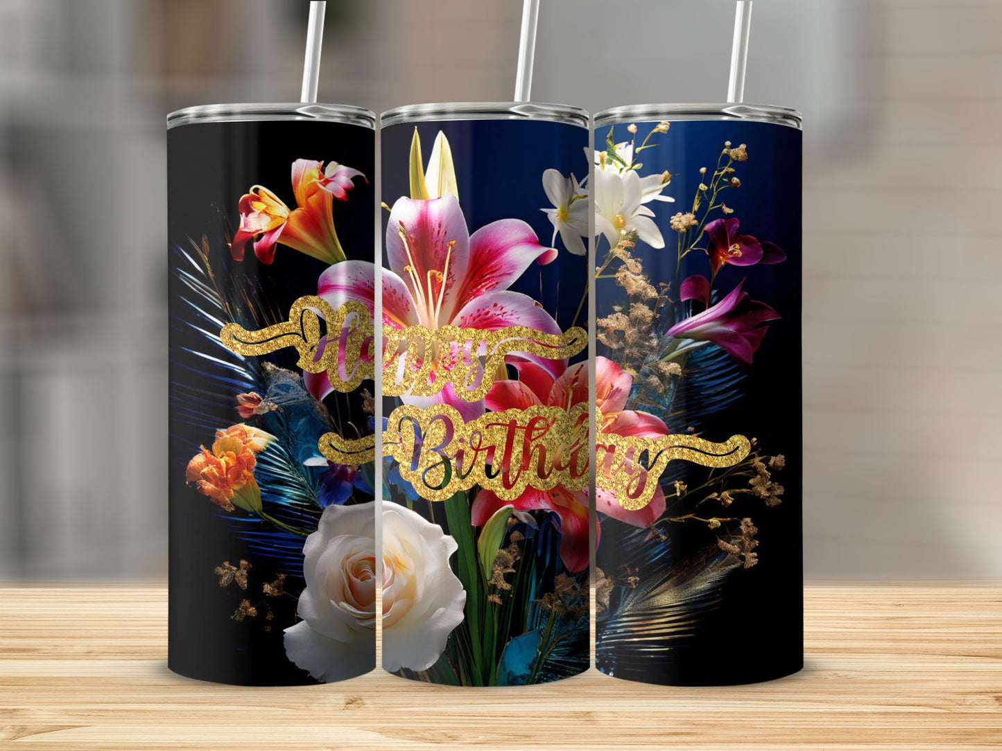 Three floral tumblers with "Happy Birthday" text on a wooden surface.
