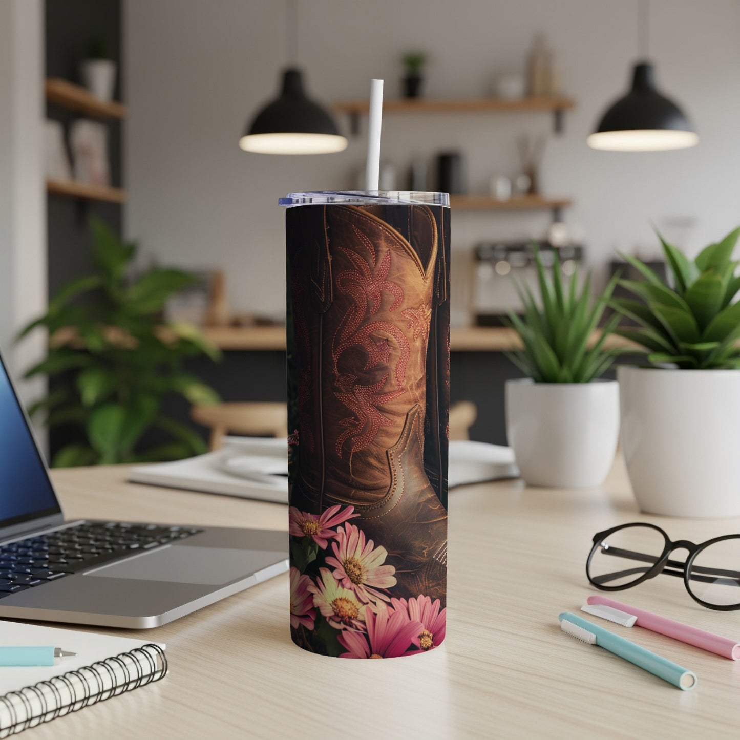 Brown leather cowboy boot with floral accents on a textured tumbler.