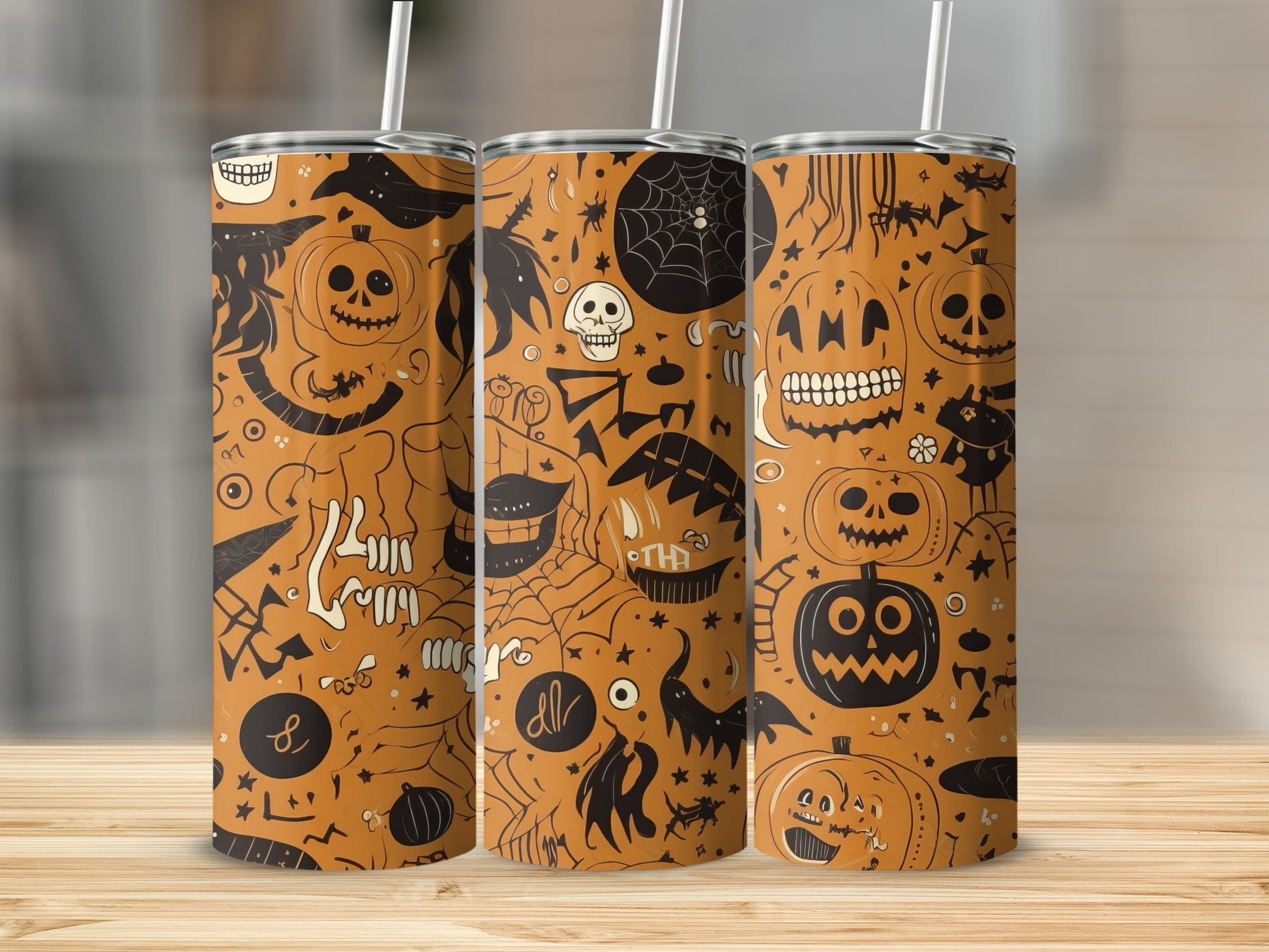 Three tumblers with a Halloween pattern featuring pumpkins, skulls, and bats.