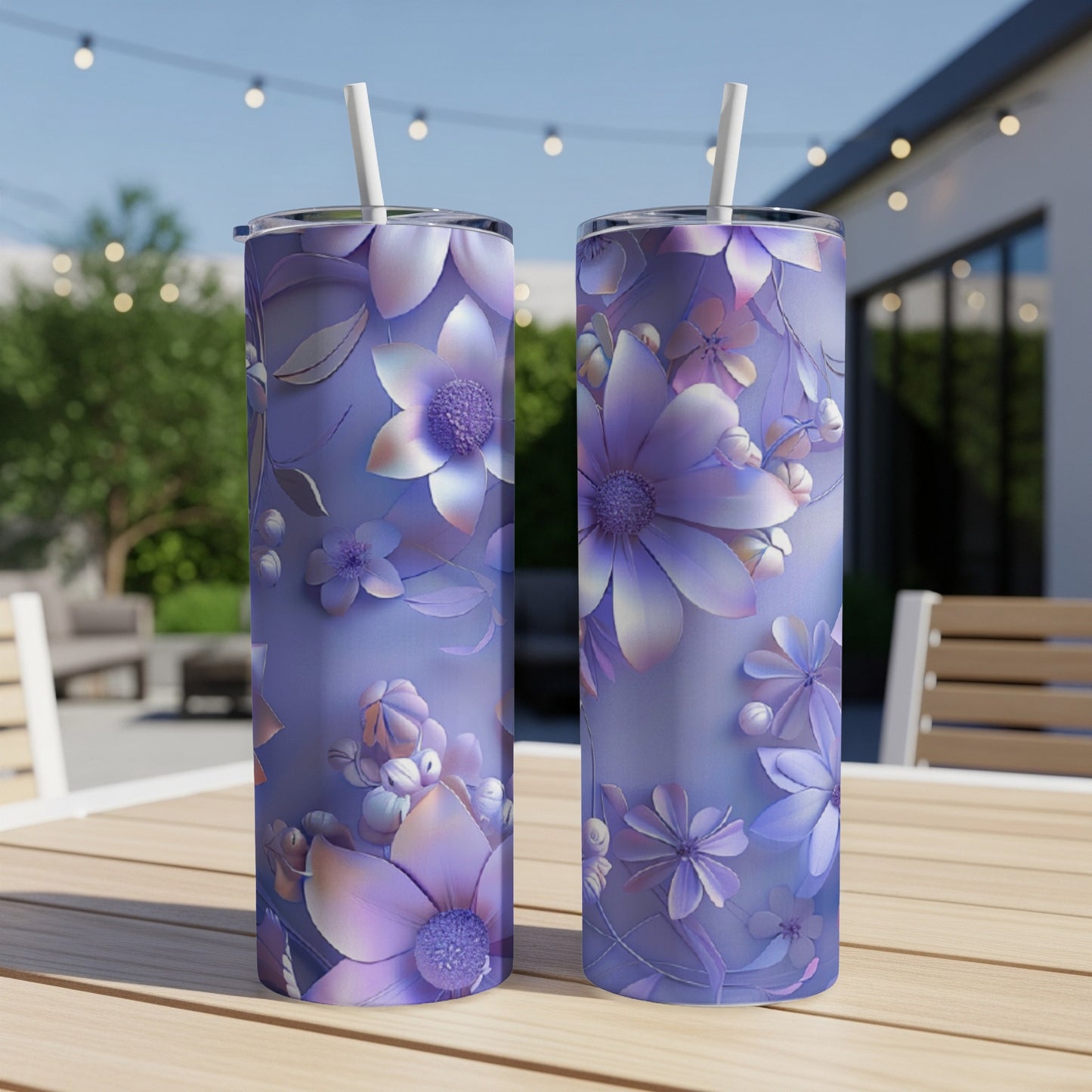 Two purple floral tumblers with straws on a table.