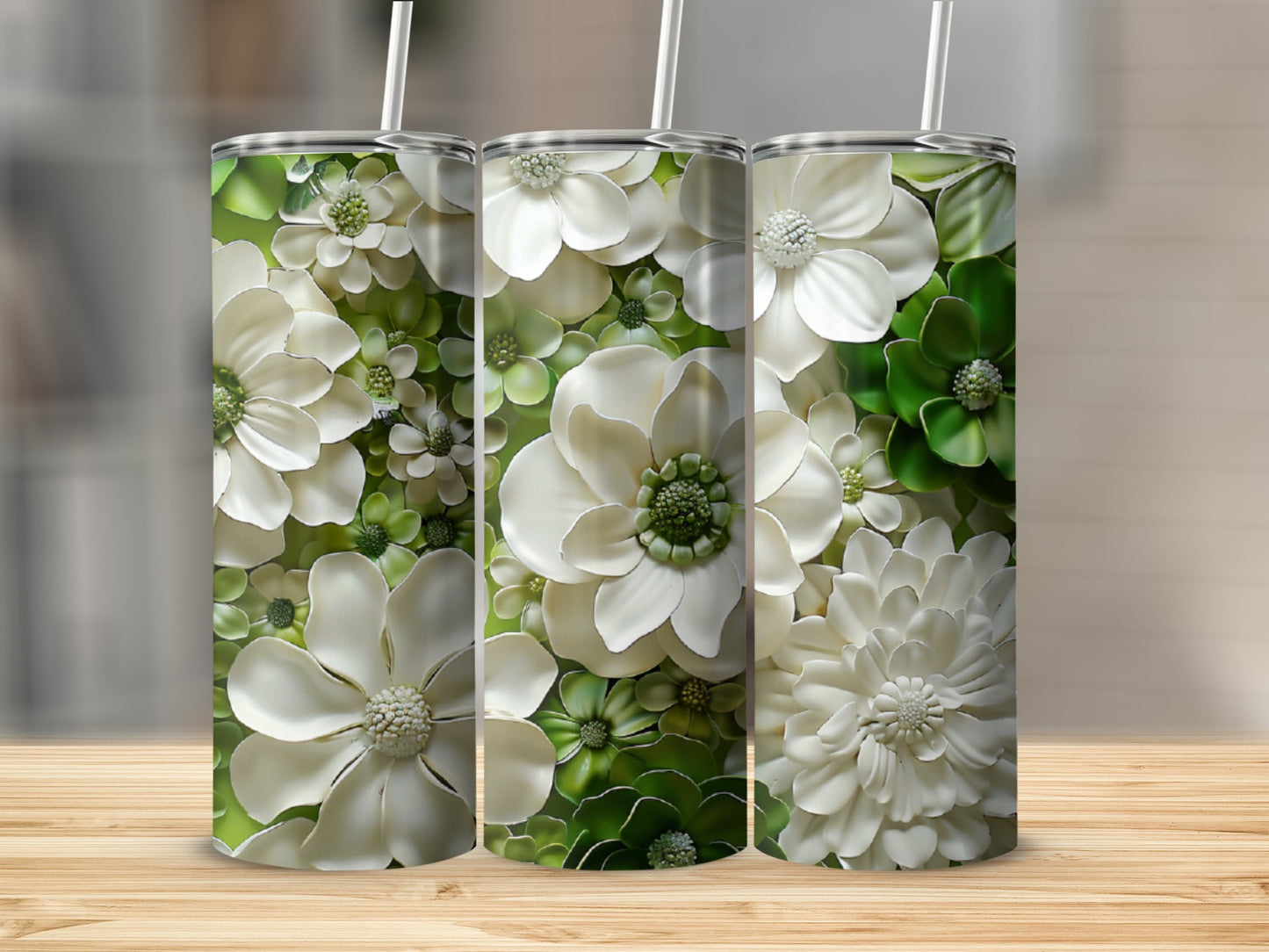 Three tumblers with a textured white and green floral design on a wooden surface.