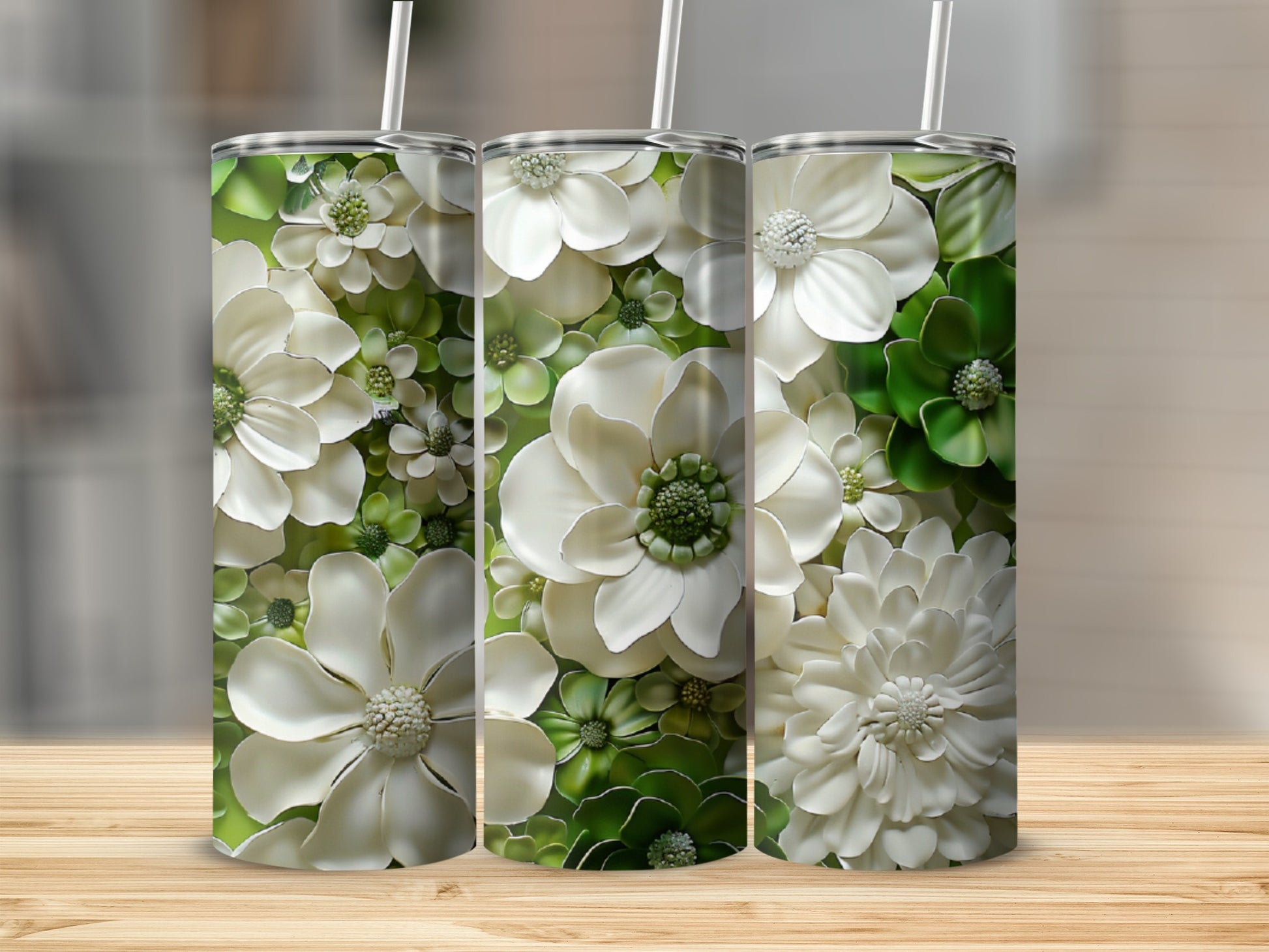 Three tumblers with a textured white and green floral design on a wooden surface.