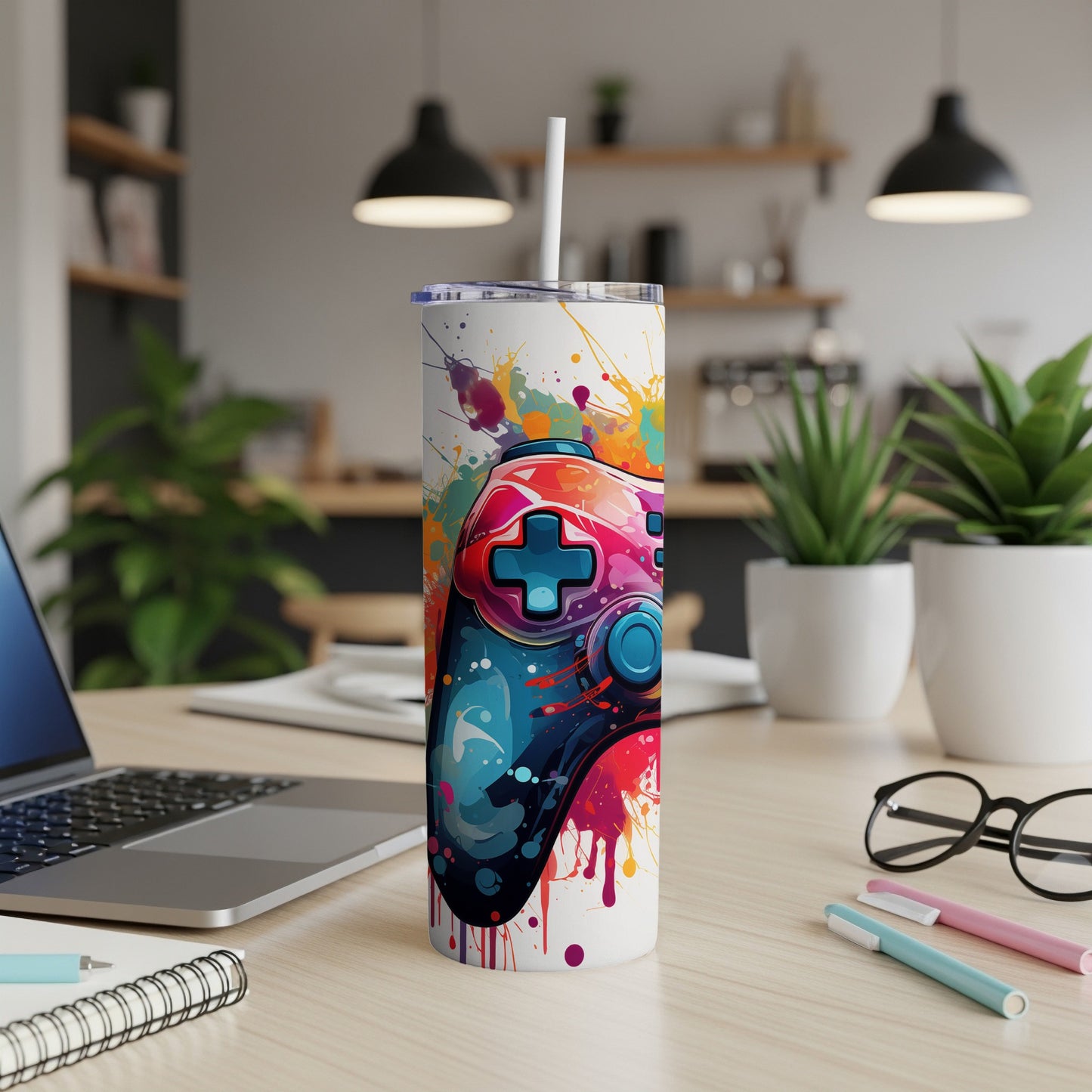 Tumbler with colorful video game controller and paint splatter design.