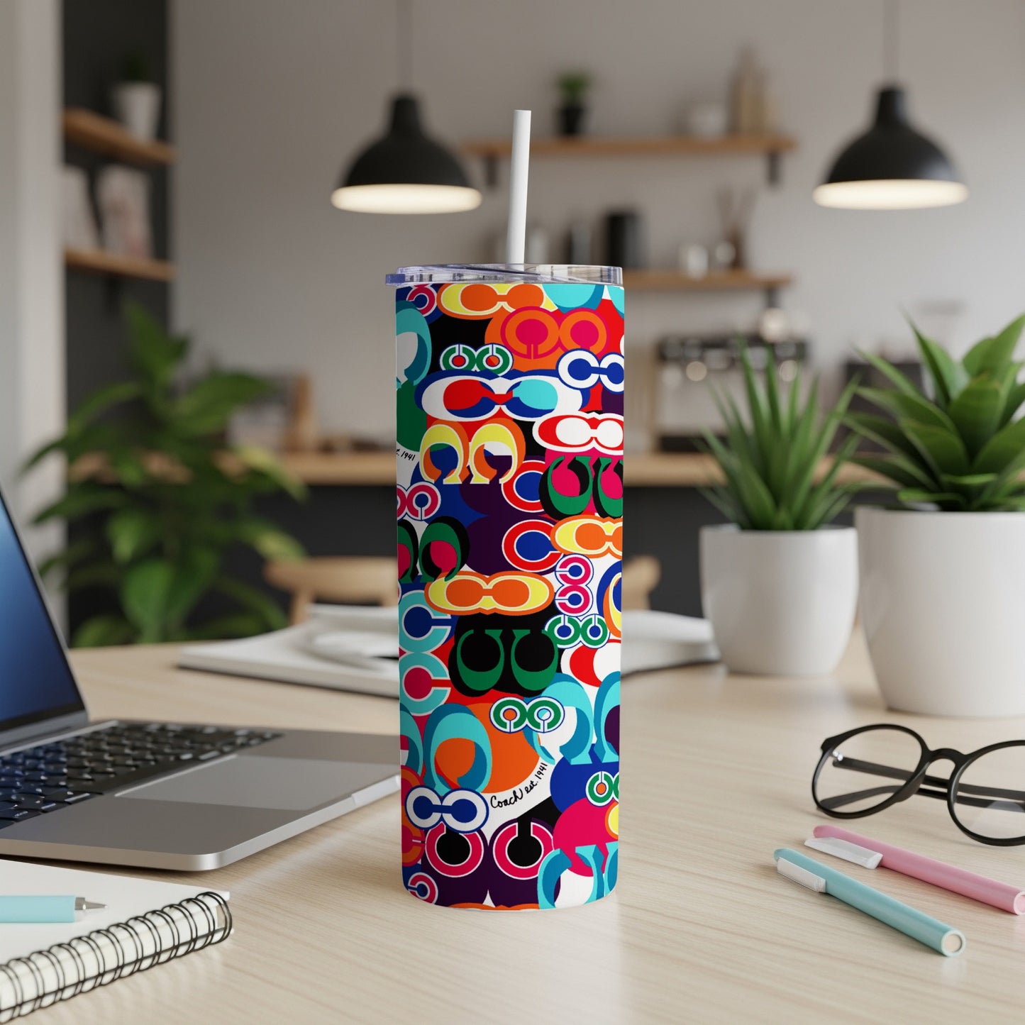 Tumbler with colorful Coach pattern and "Coach est. 1941" text.