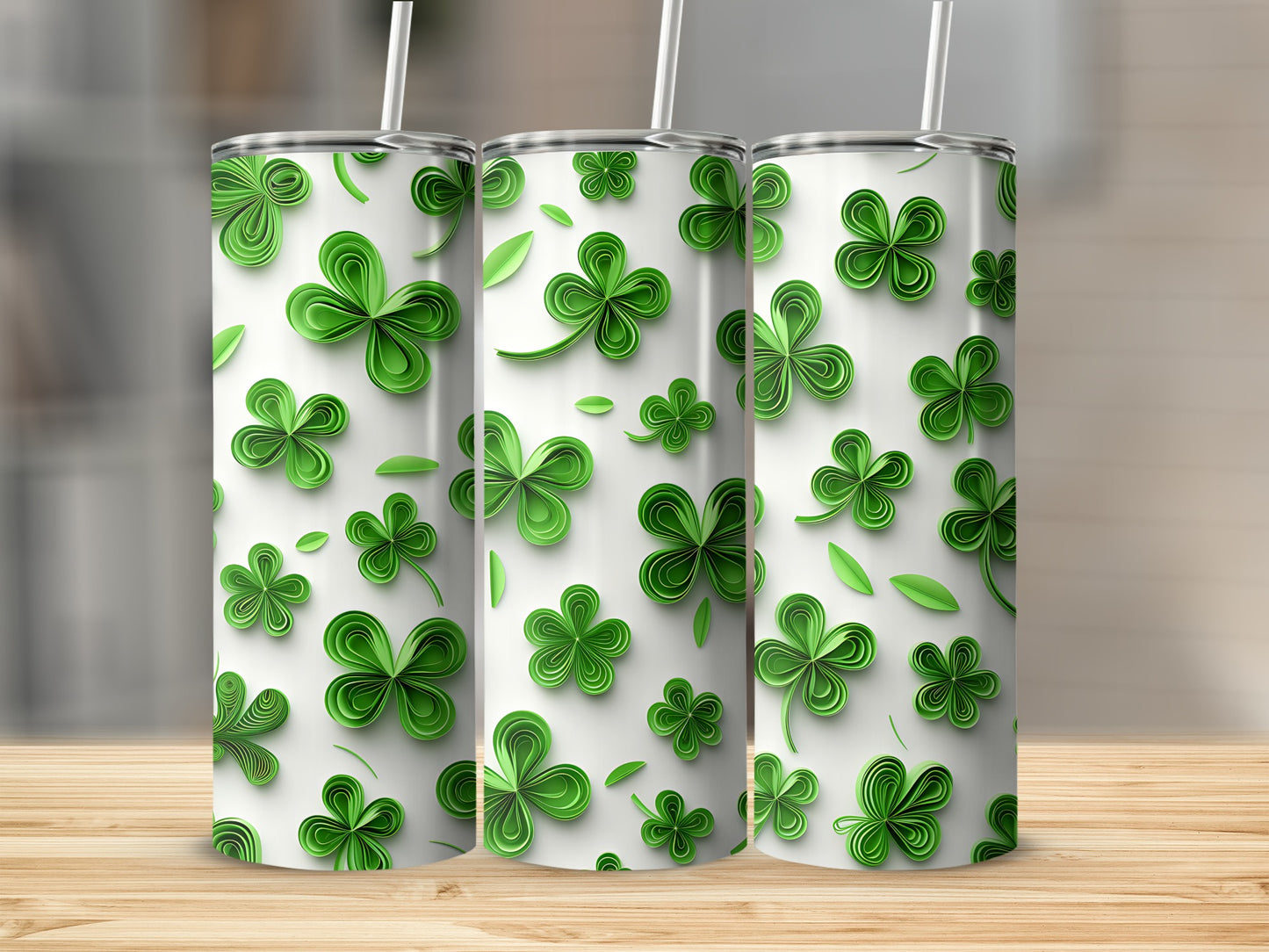 Three green shamrock pattern tumblers with straws on a wooden surface.