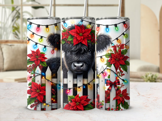 Cow with Christmas lights and poinsettias on a tumbler.