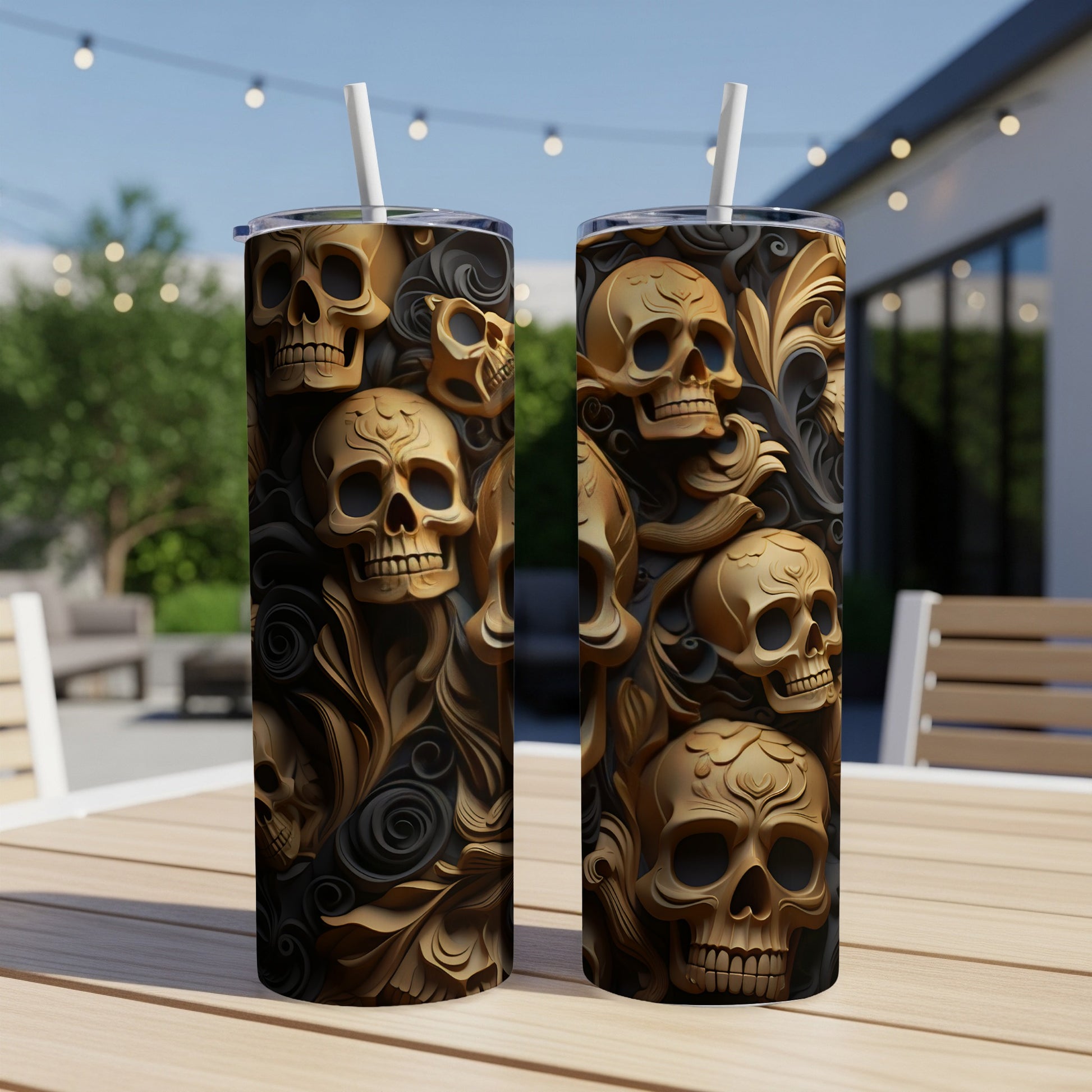 Two gold skull tumblers with ornate floral patterns on a wooden table.