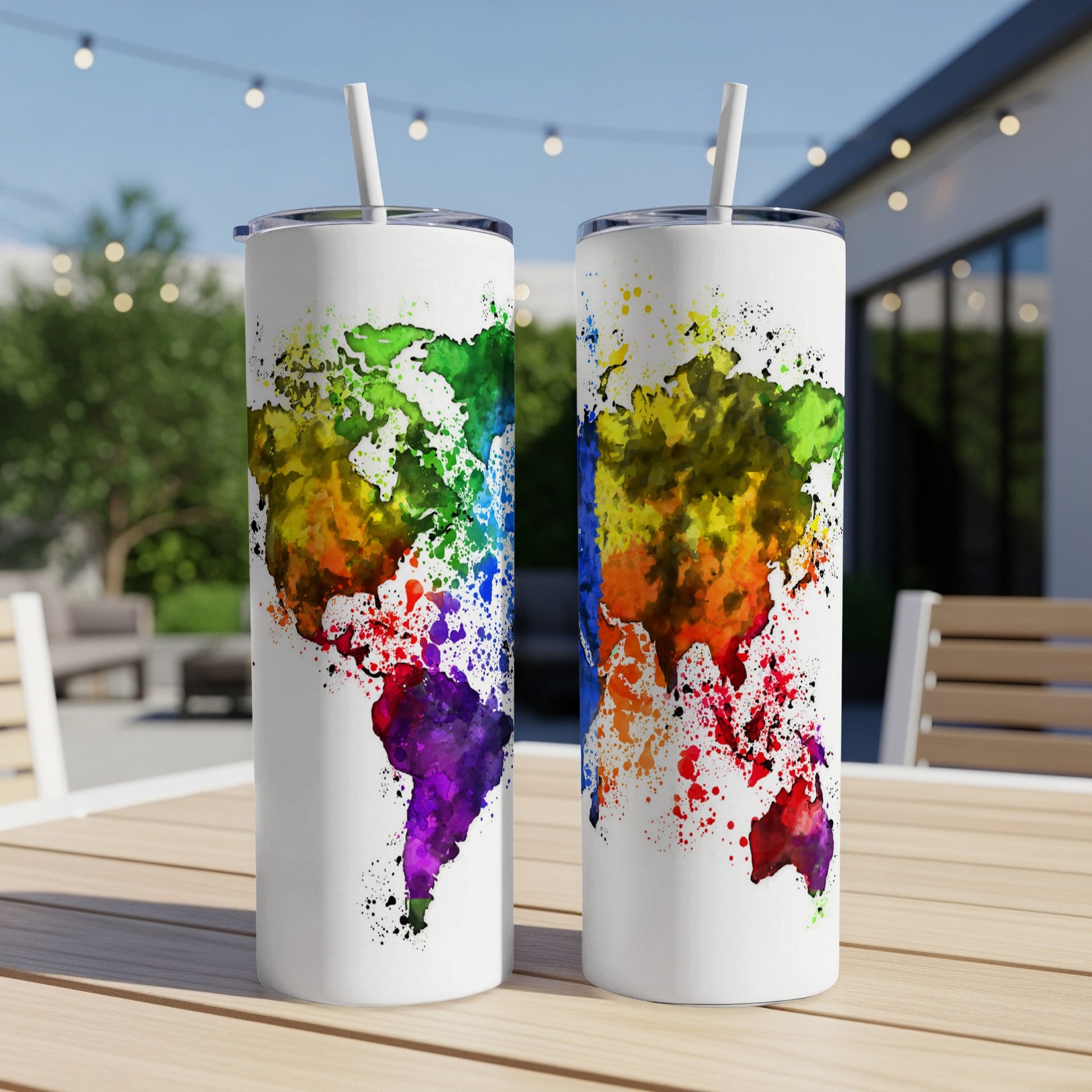 Two white tumblers with colorful watercolor world map designs stand on a table.