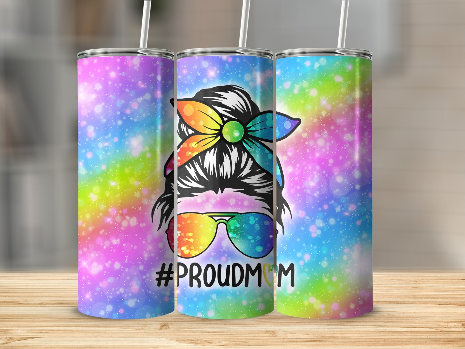 Rainbow glitter tumbler with #PROUDMOM text and messy bun woman graphic.