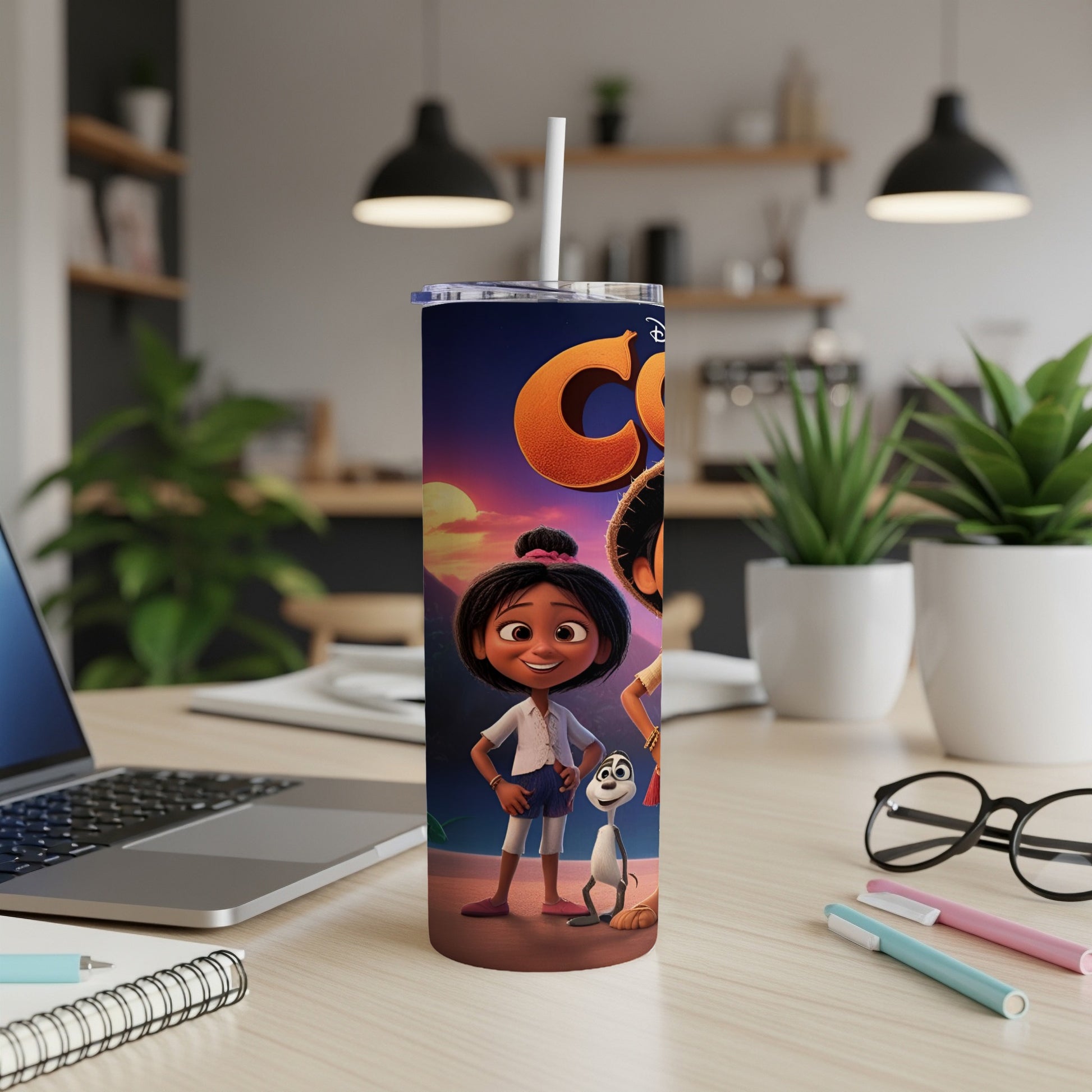 Cartoon girl and dog on a colorful tumbler next to a laptop.