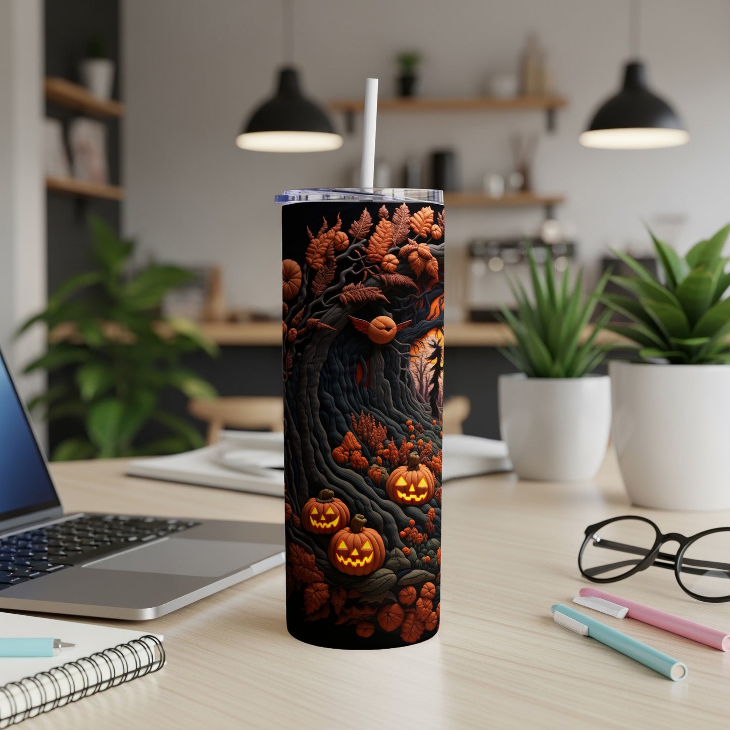 Black tumbler with a Halloween tree, pumpkins, and autumn leaves design.