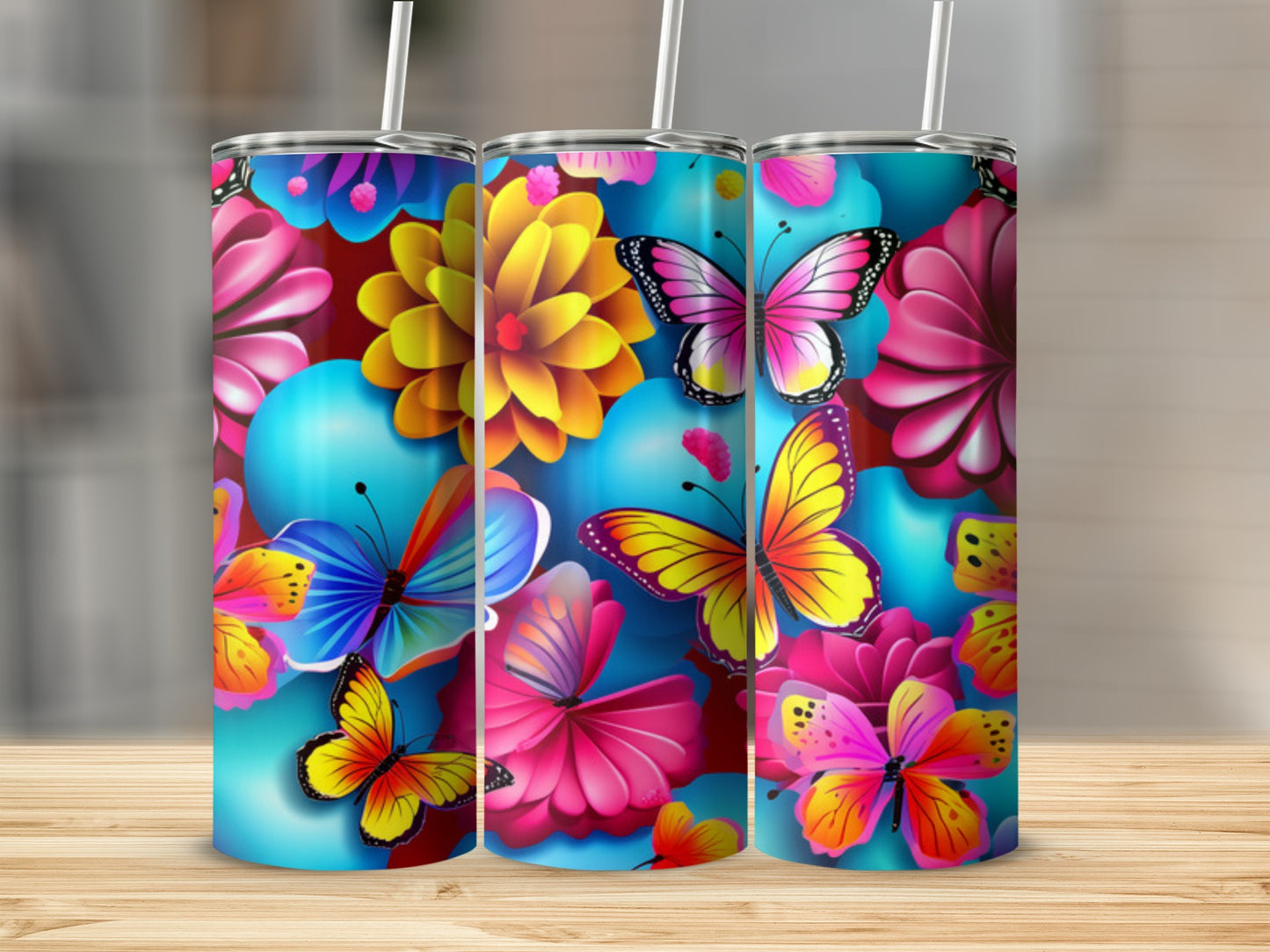 Three tumblers with colorful butterflies and flowers on a wooden surface.