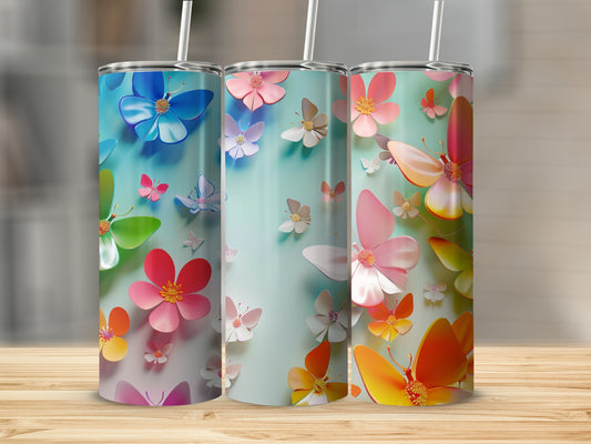 Three tumblers with colorful butterflies and floral designs on a wooden surface.