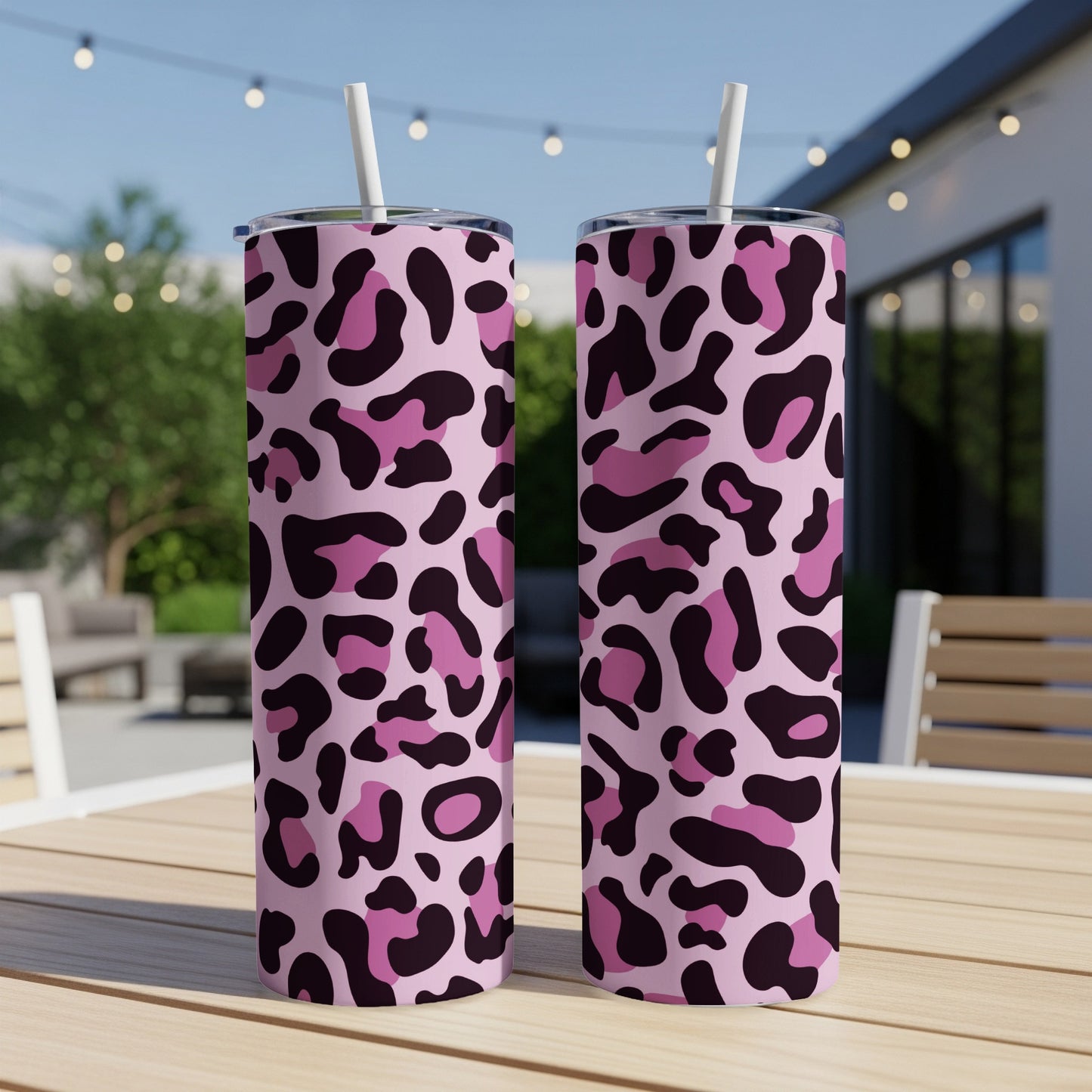 Two tall tumblers with a pink, purple, and black leopard print pattern, each with a white straw.